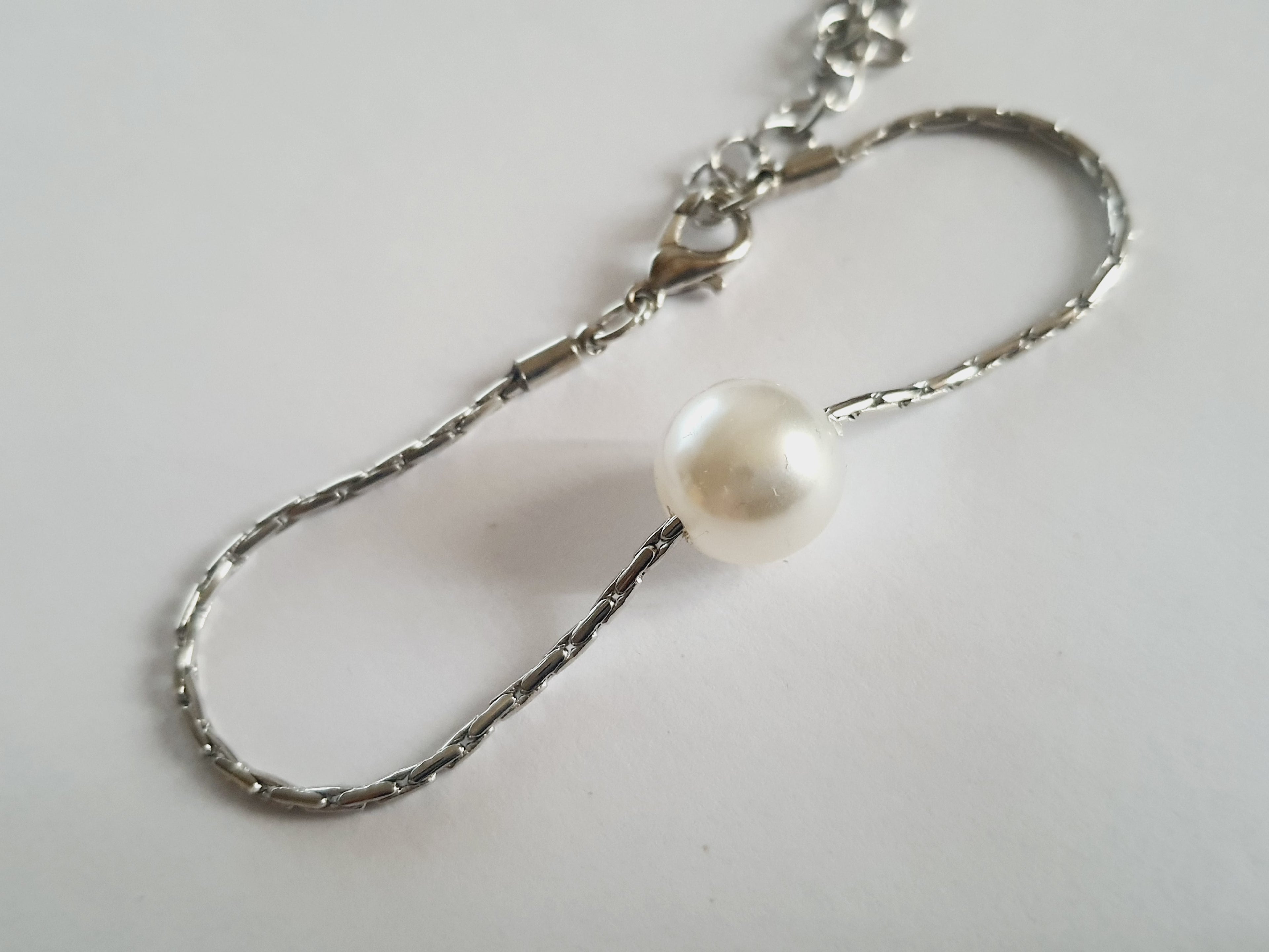 Srebrna bransoletka z dużą białą perłą na środku, elegancka i klasyczna. Stal nierdzewna, stal chirurgiczna, wodoodporne, hipoalergiczne, jakość premium, Rouge Bizu.