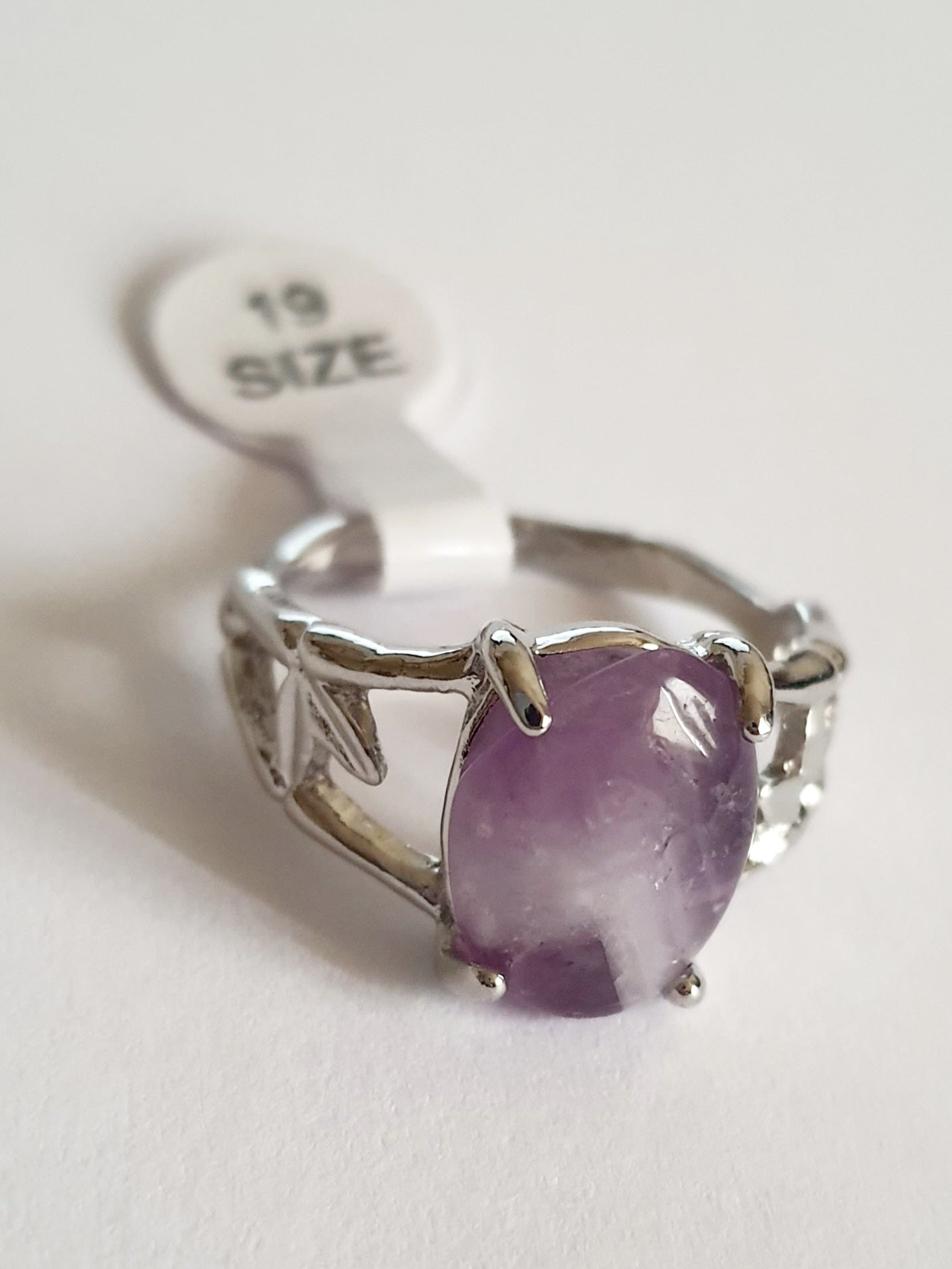 Srebrny pierścionek z fioletowym kamieniem przypominającym ametyst, w romantycznym stylu. Stal chirurgiczna, delikatne metalowe zdobienia przypominające gałązki. Rozmiar 19 mm. Rouge Bizu.
