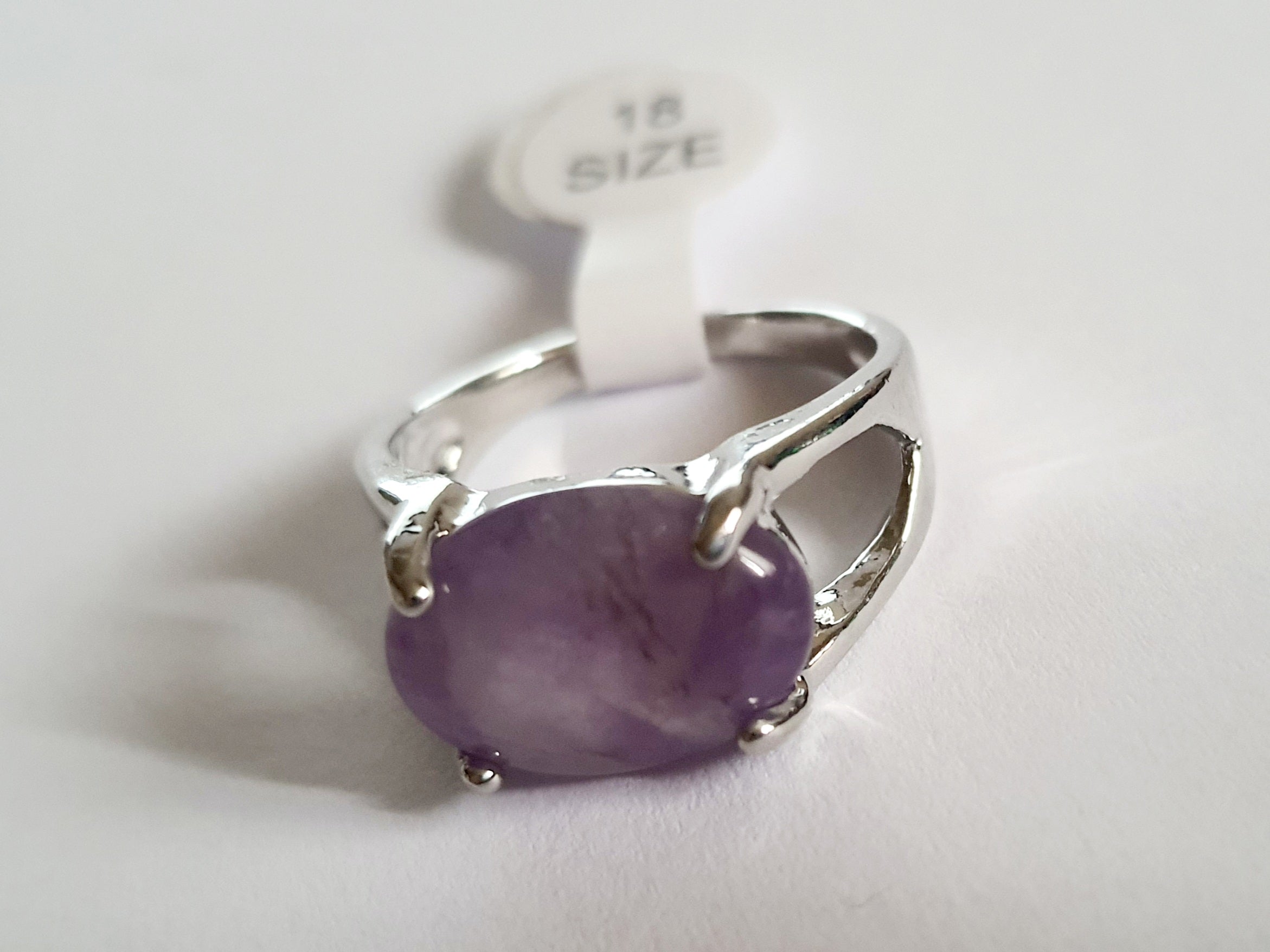 Srebrny pierścionek ze stali nierdzewnej z owalnym, fioletowym kamieniem w stylu minimalistycznym i delikatnym. Klasyczny, kobiecy design. Rozmiar 18 mm. Rouge Bizu.