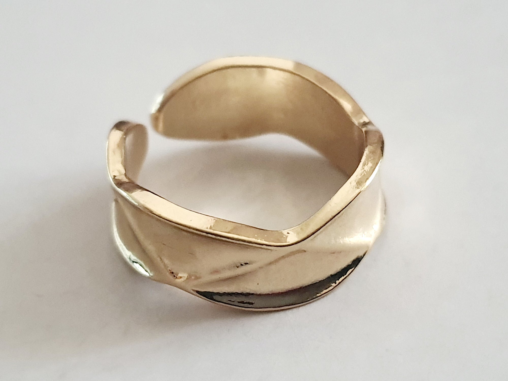 Złoty pierścionek ze stali nierdzewnej, minimalistyczny z delikatnie falistą obrączką. Rozmiar 16 mm. Styl nowoczesny i elegancki. Rouge Bizu.