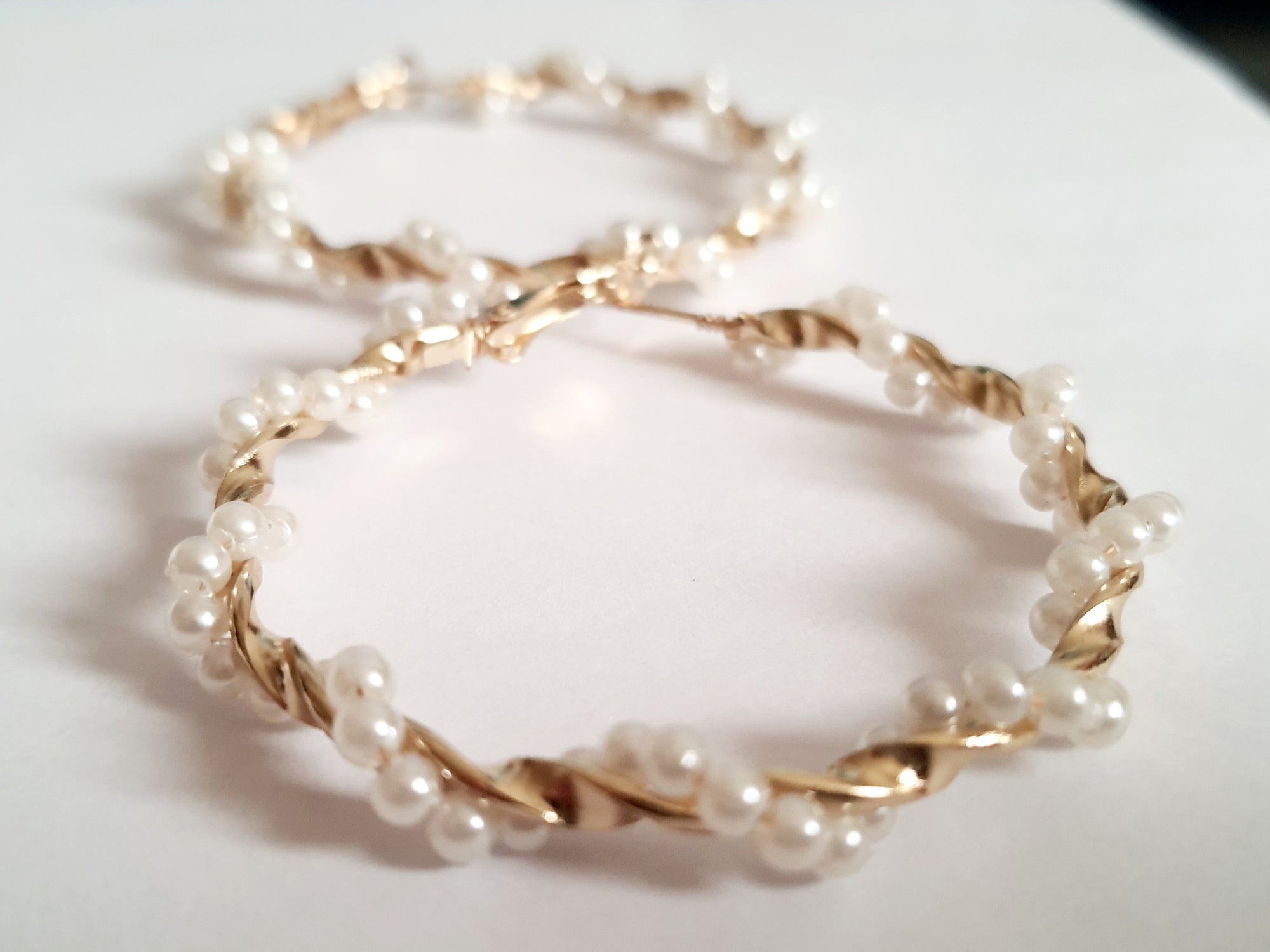 Gold hoop earrings with pearl weave – an elegant classic with a twist