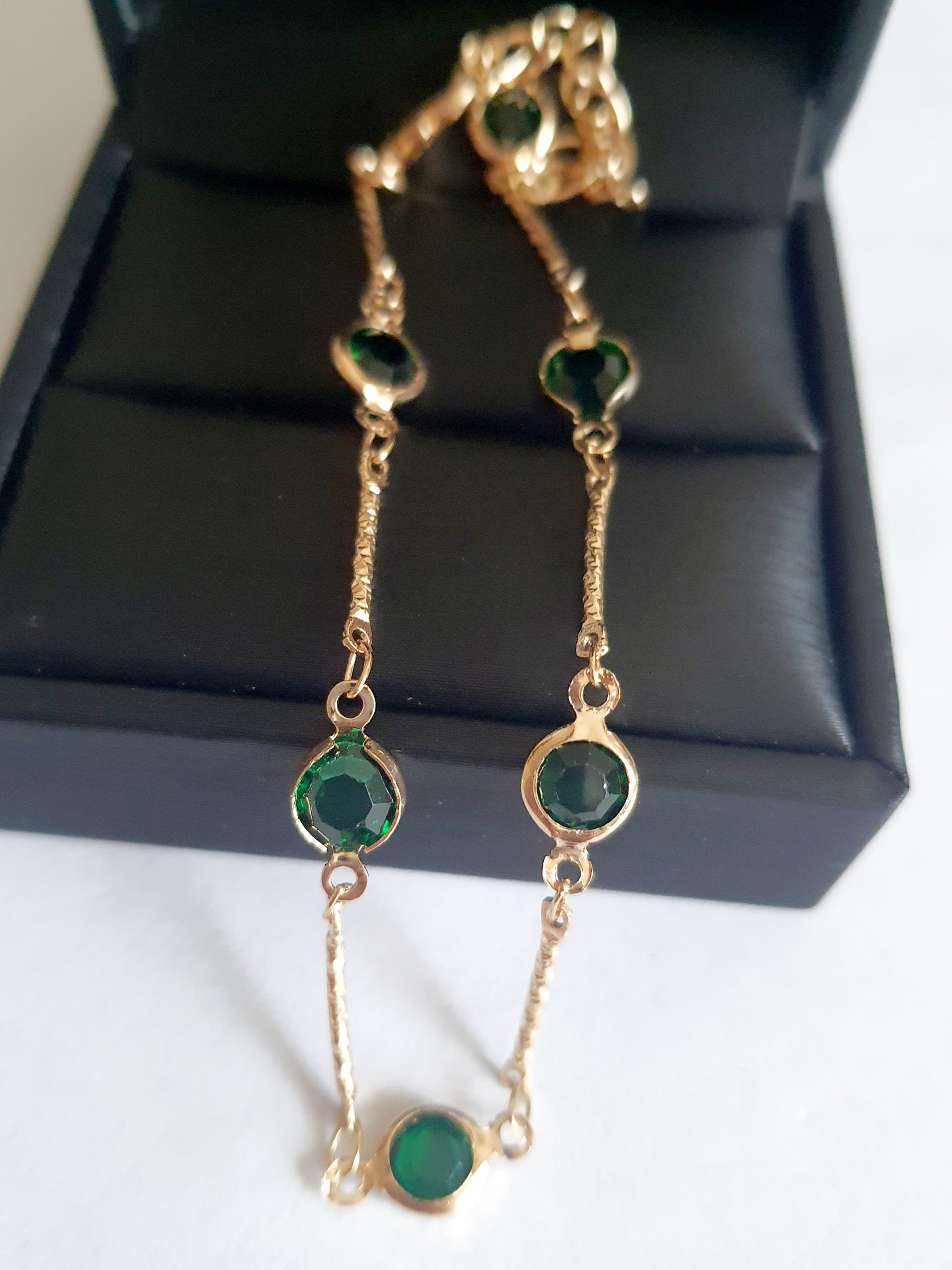 Bransoletka z szmaragdowymi cyrkoniami, złoty łańcuszek, regulowana długość 20–25 cm. Delikatna, elegancka, klasyczna biżuteria ze stali nierdzewnej. Rouge Bizu.