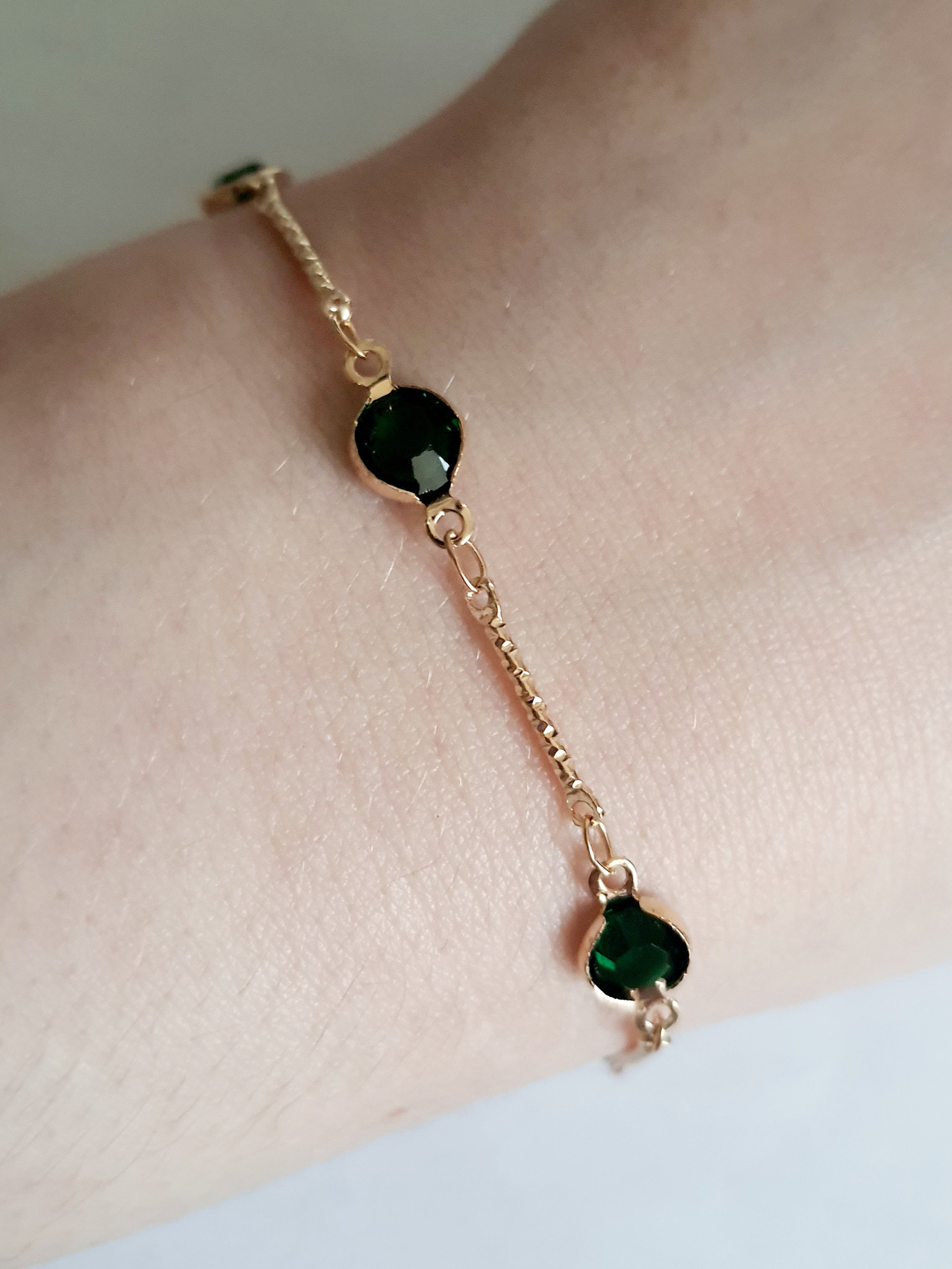 Bransoletka z szmaragdowymi cyrkoniami, złoty łańcuszek, regulowana długość 20–25 cm. Delikatna, elegancka, klasyczna biżuteria ze stali nierdzewnej. Rouge Bizu.