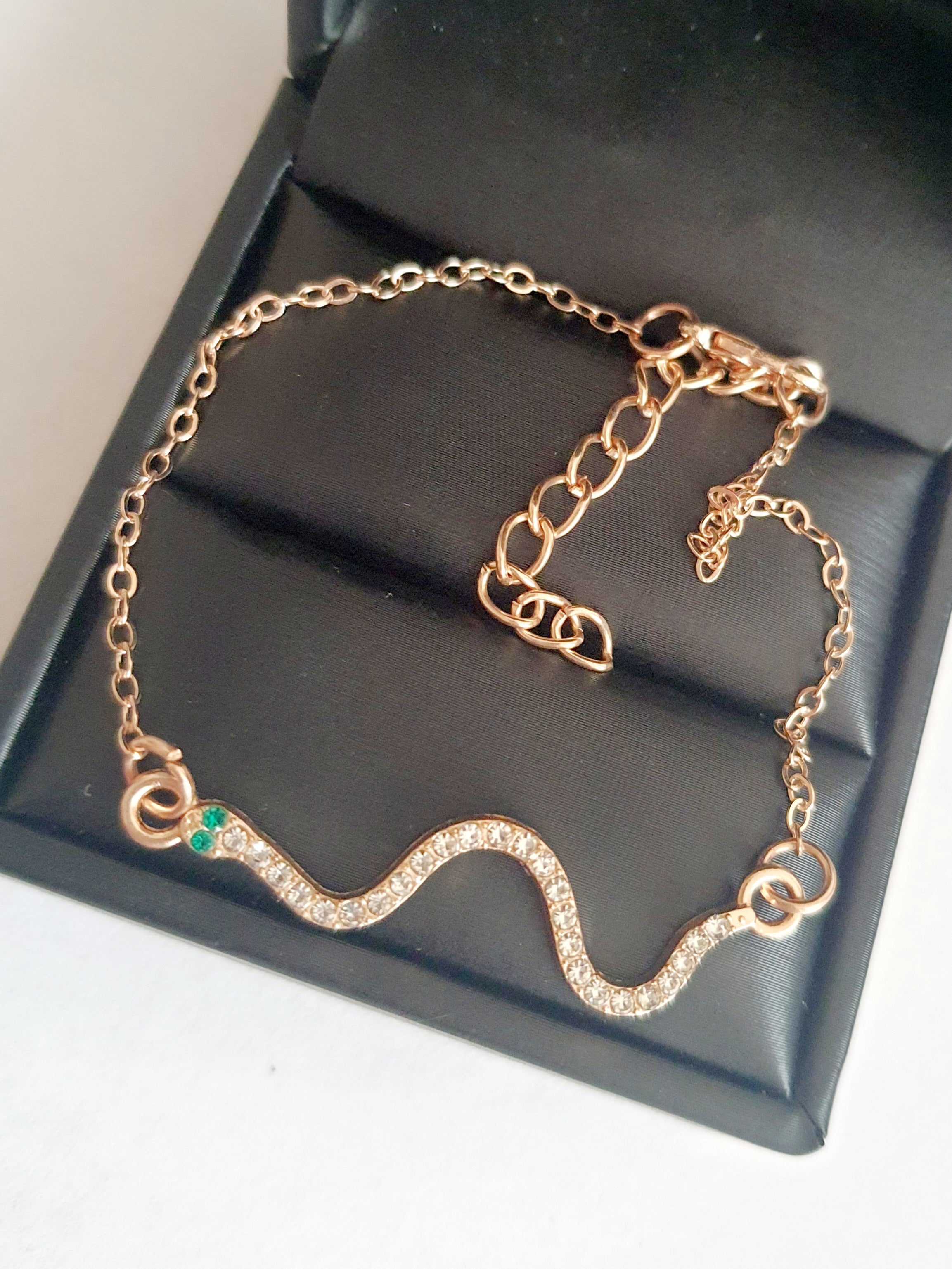 Bransoletka żmijka z cyrkoniami, złota, z zielonymi oczkami węża, długość 20–25 cm. Mistyczna, przyciągająca spojrzenia. Stal nierdzewna. Rouge Bizu.