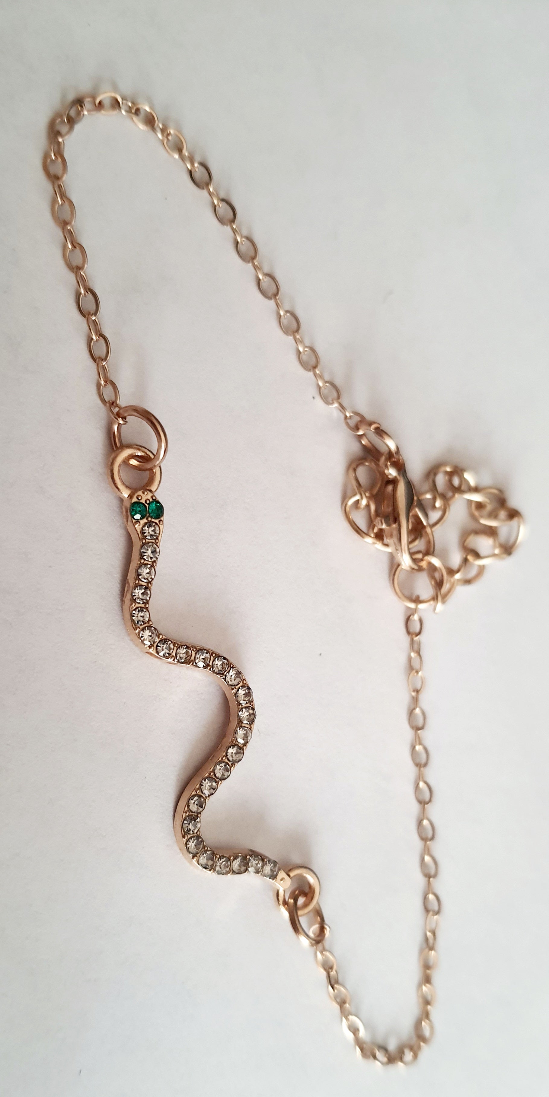 Bransoletka żmijka z cyrkoniami, złota, z zielonymi oczkami węża, długość 20–25 cm. Mistyczna, przyciągająca spojrzenia. Stal nierdzewna. Rouge Bizu.