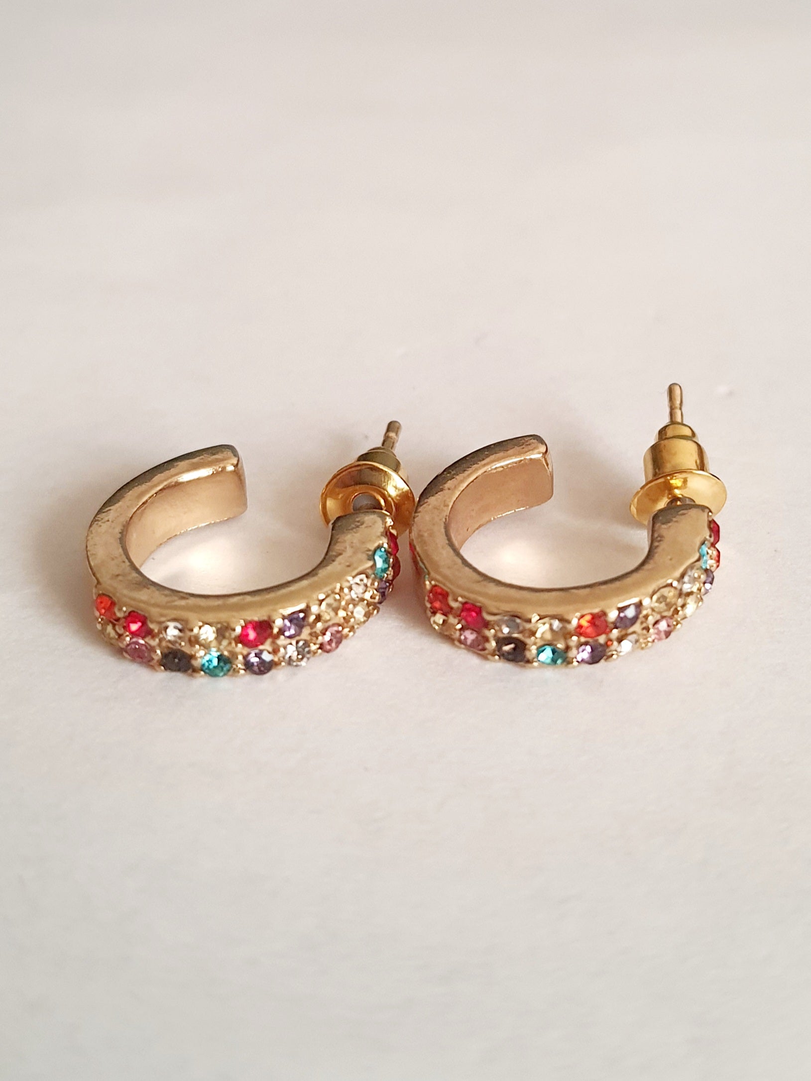 Zestaw 3 par złotych kolczyków typu kółka: kolorowe cyrkonie (1,5 cm), wypustki (1,5 cm), klasyczne z cyrkonią (1 cm). Zapięcie na sztyft. Rouge bizu