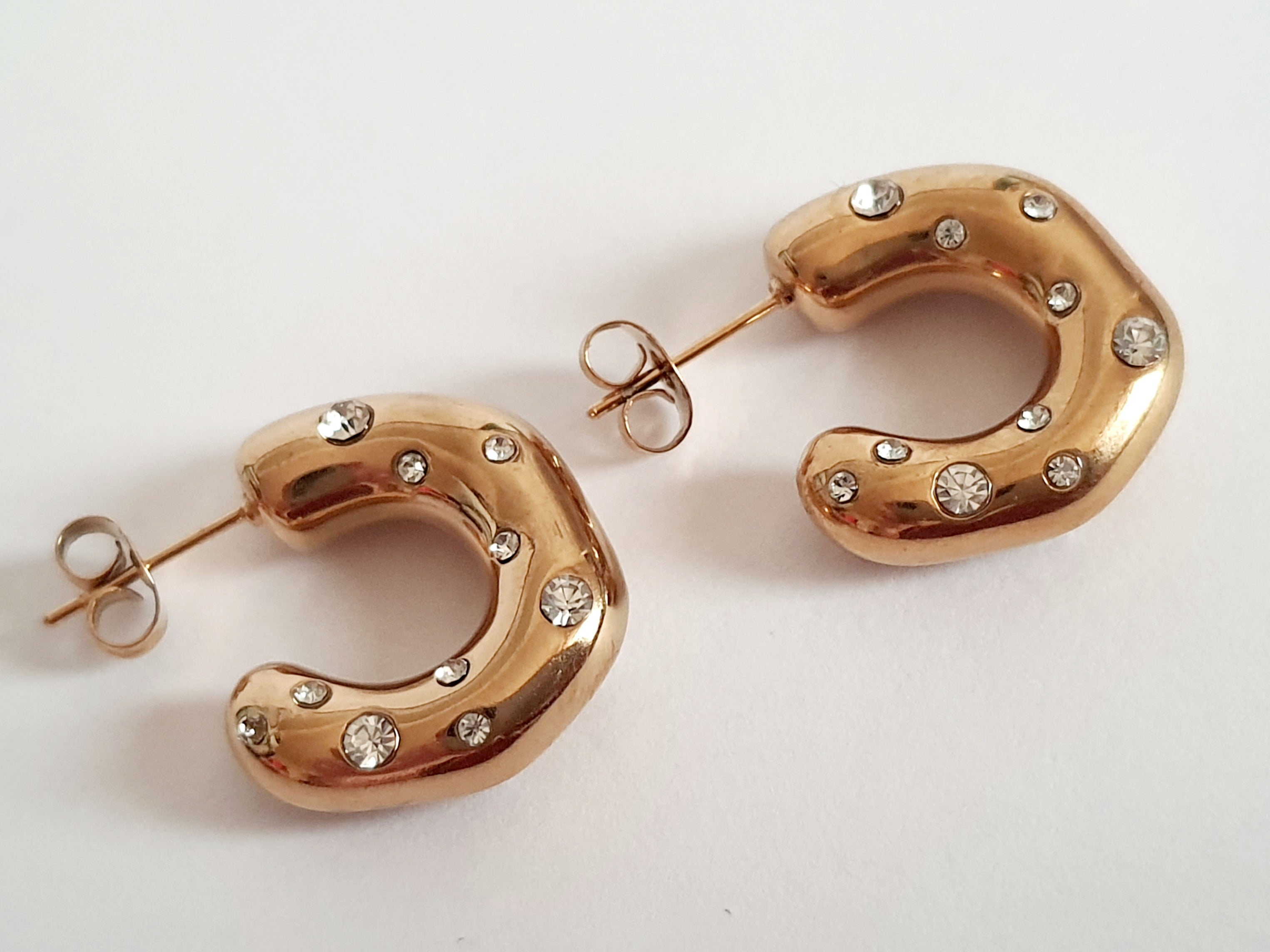 Kolczyki półokręgi 2 cm, stal nierdzewna w złotym kolorze, zdobione białymi cyrkoniami, zapięcie na sztyft. Rouge Bizu.