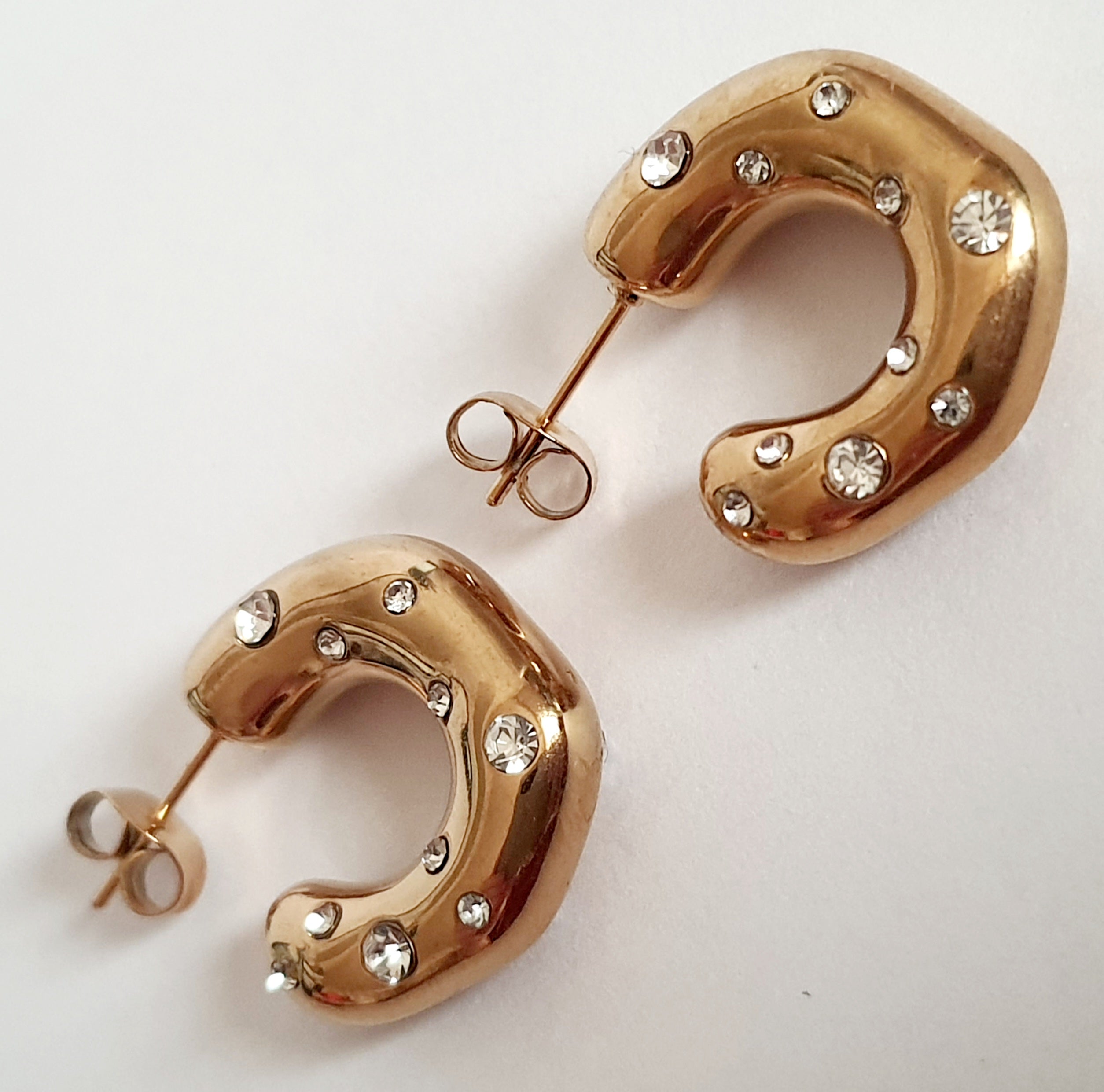 Kolczyki półokręgi 2 cm, stal nierdzewna w złotym kolorze, zdobione białymi cyrkoniami, zapięcie na sztyft. Rouge Bizu.