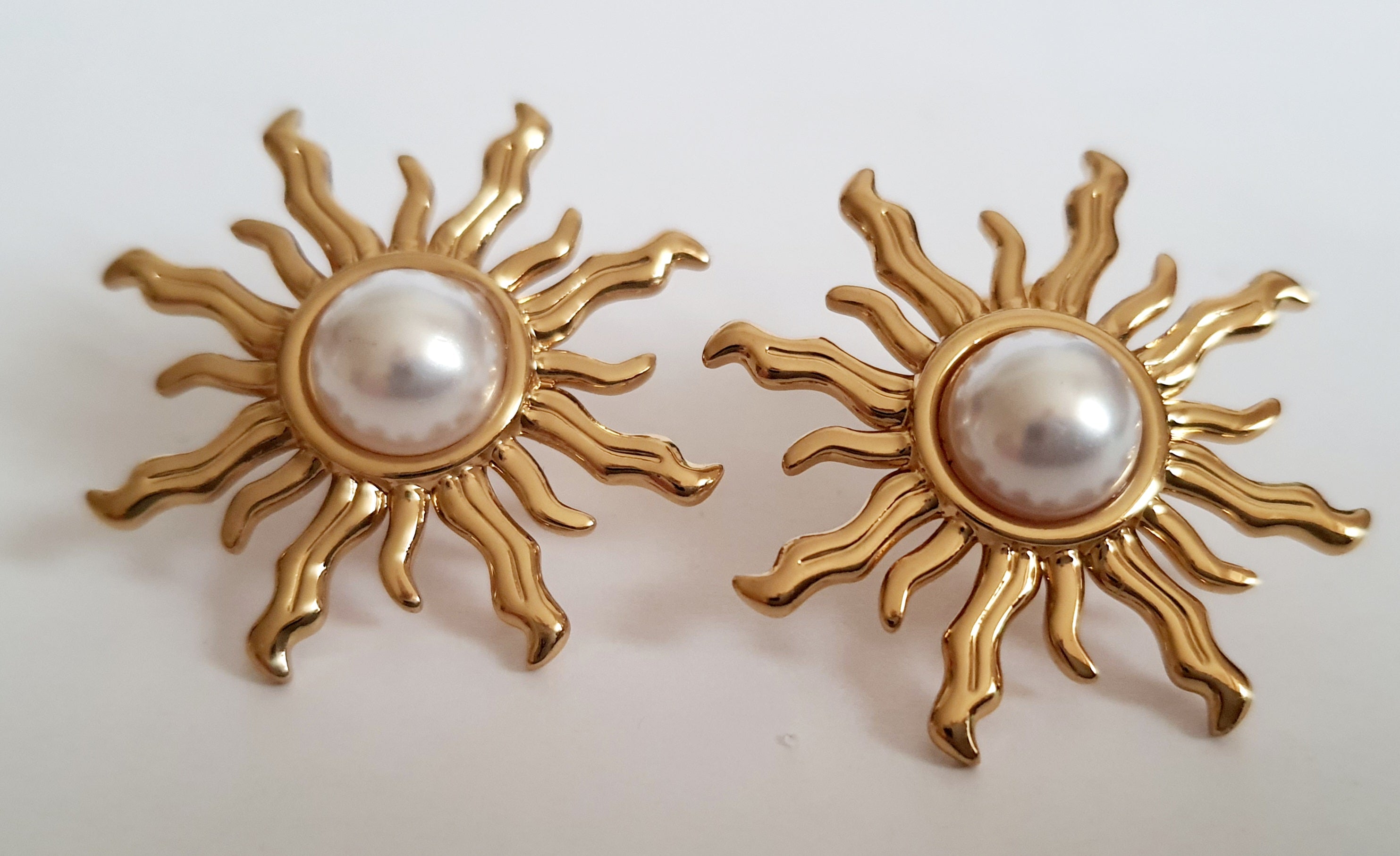 Złote kolczyki ze stali nierdzewnej w kształcie słońca z perłowym środkiem, średnica 3 cm, styl artystyczny i glamour. Rouge Bizu.