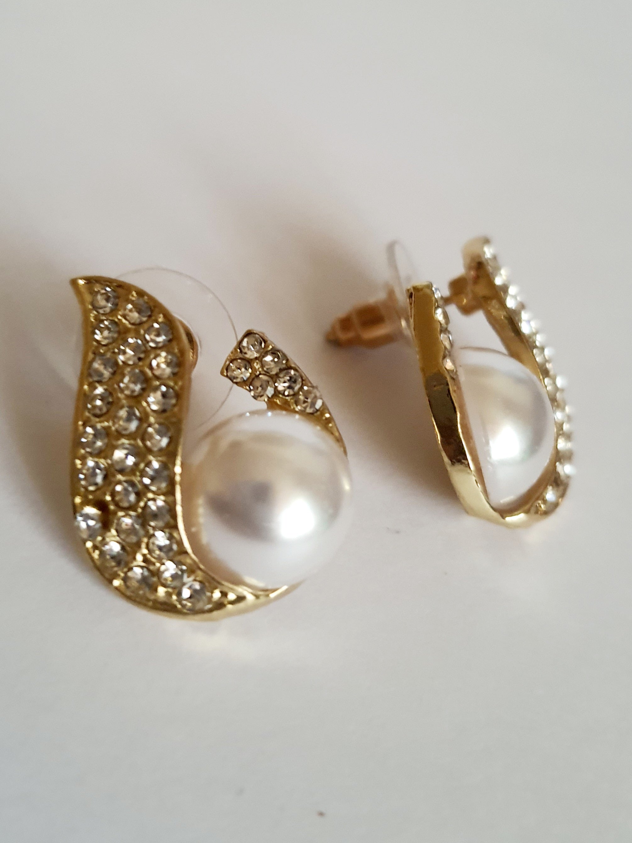 Kolczyki złote ze stali nierdzewnej o długości 2 cm, z białą perłą i oprawą wysadzaną cyrkoniami, elegancki kształt z falującą linią, Rouge Bizu.