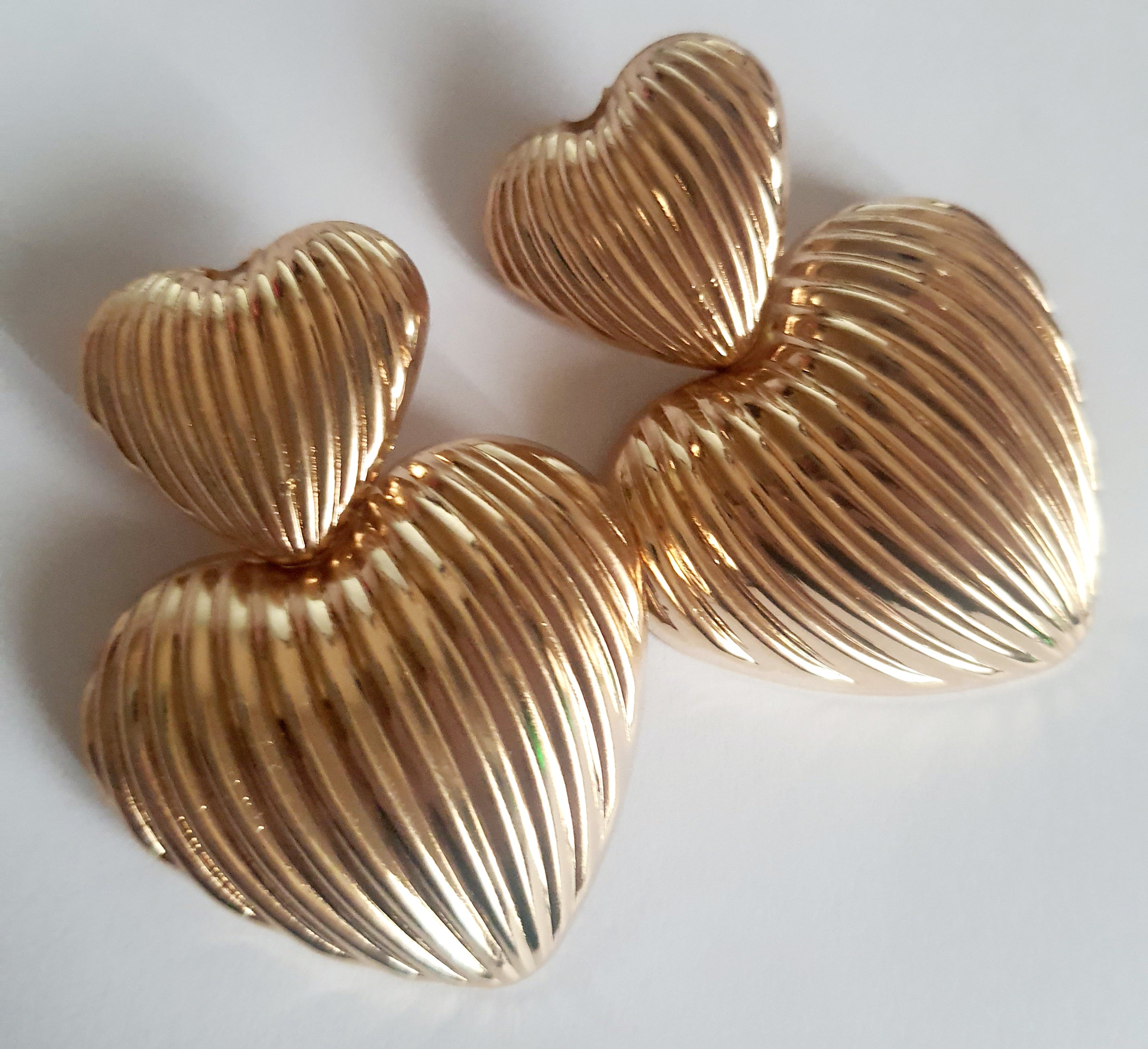 Złote kolczyki w kształcie serc, duże i eleganckie, ze żłobieniami nadającymi im wyjątkowego blasku. Wykonane ze stali nierdzewnej. Rouge Bizu.