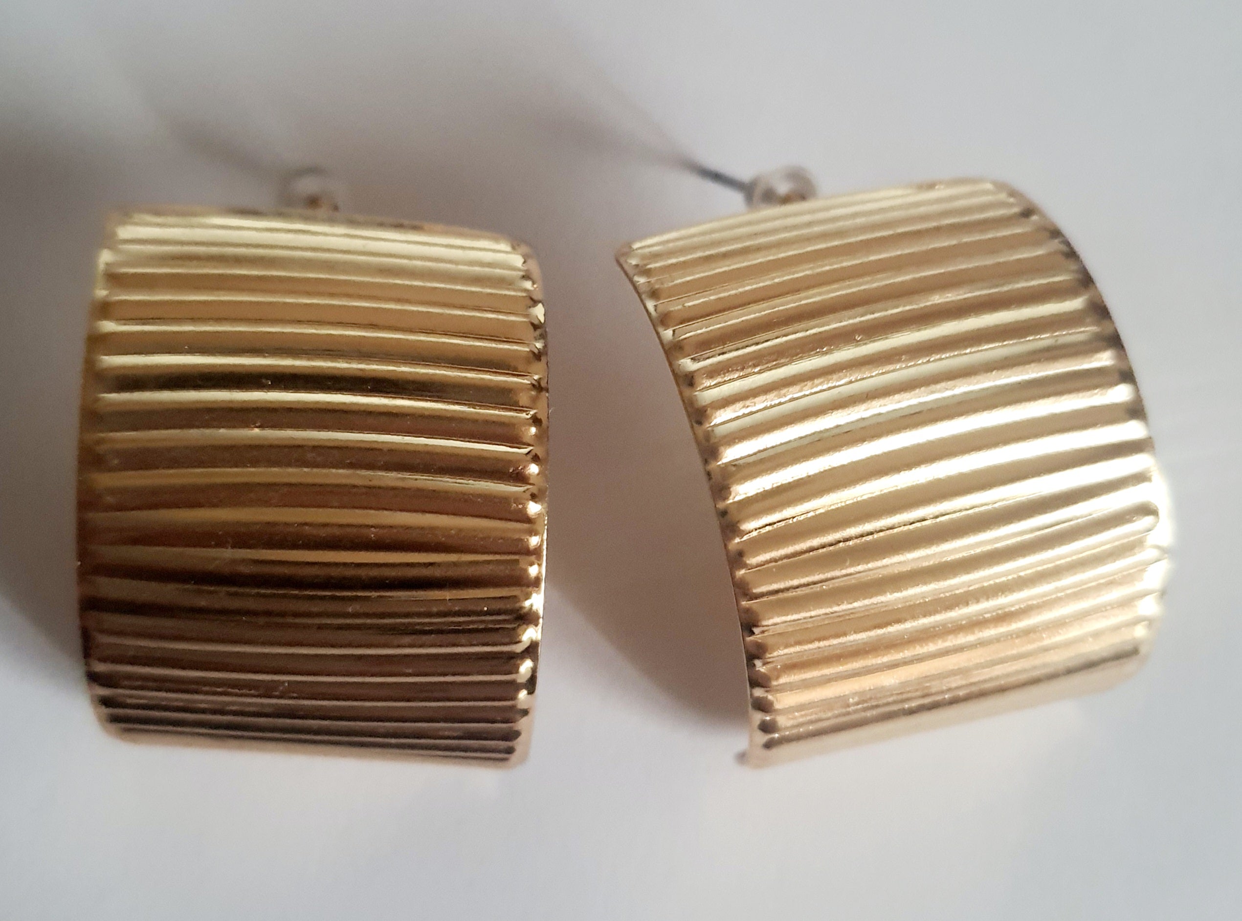 Złote kolczyki szerokie z pionowym tłoczeniem, minimalistyczne i eleganckie. Stal nierdzewna, długość 3 cm. Rouge Bizu.