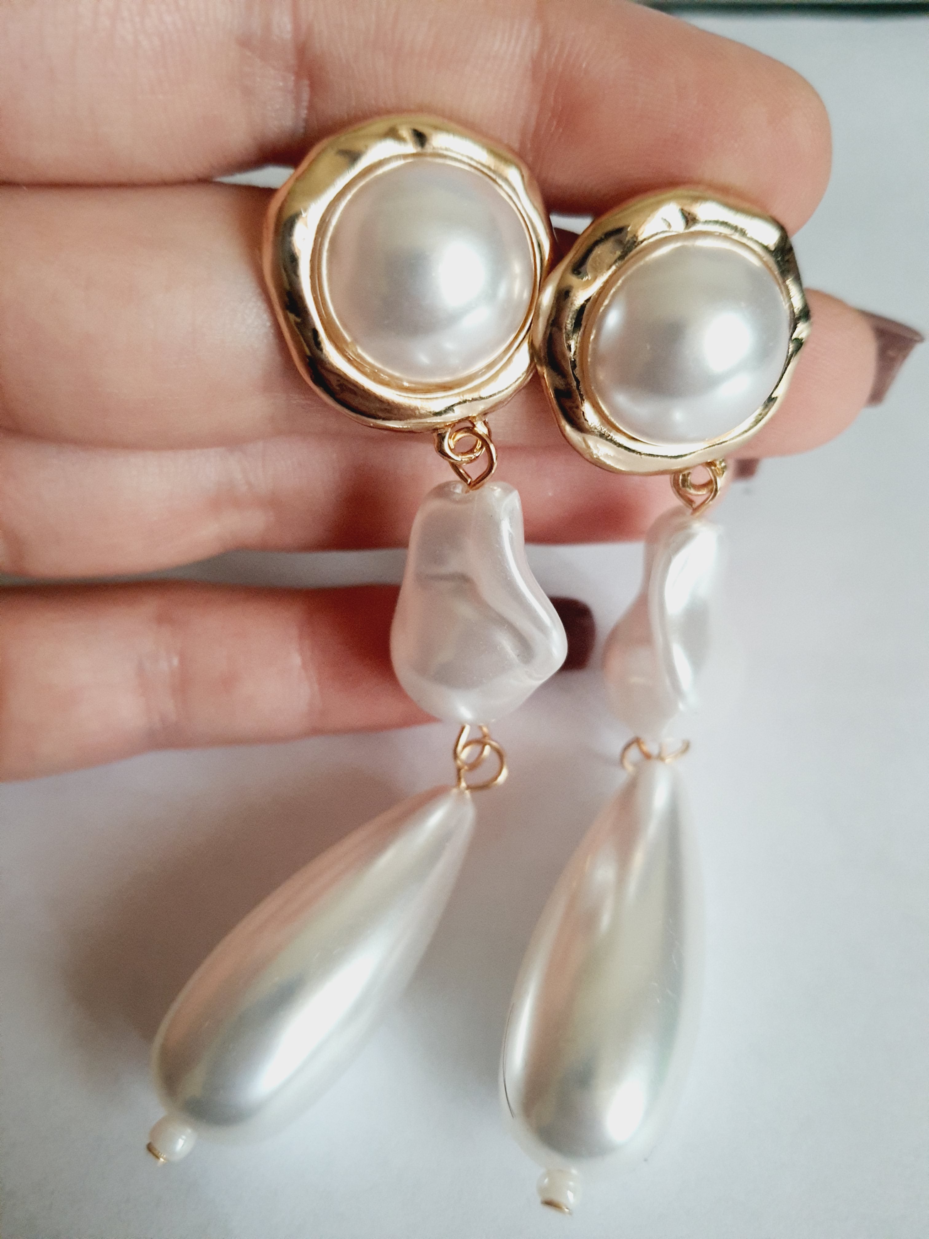 Długie złote kolczyki ze stali nierdzewnej z potrójnymi perłami: okrągłą, nieregularną i kroplą. Styl glamour, klasyczna elegancja. Długość 9 cm. Rouge Bizu.