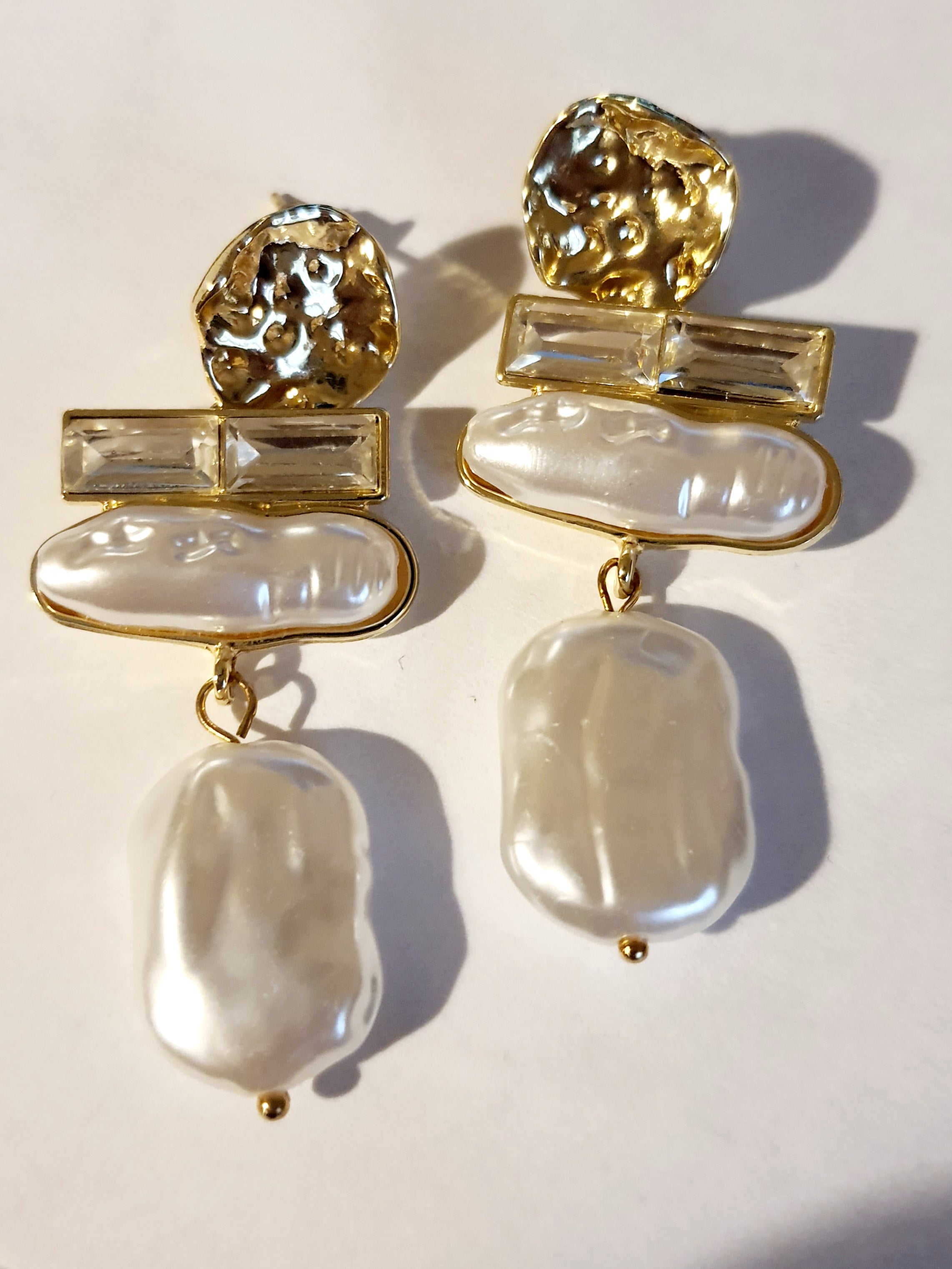 „Złote kolczyki ze stali nierdzewnej o długości 6 cm, zdobione nieregularnymi perłami barokowymi oraz prostokątnymi kryształami, eleganckie i stylowe – Rouge Bizu.”