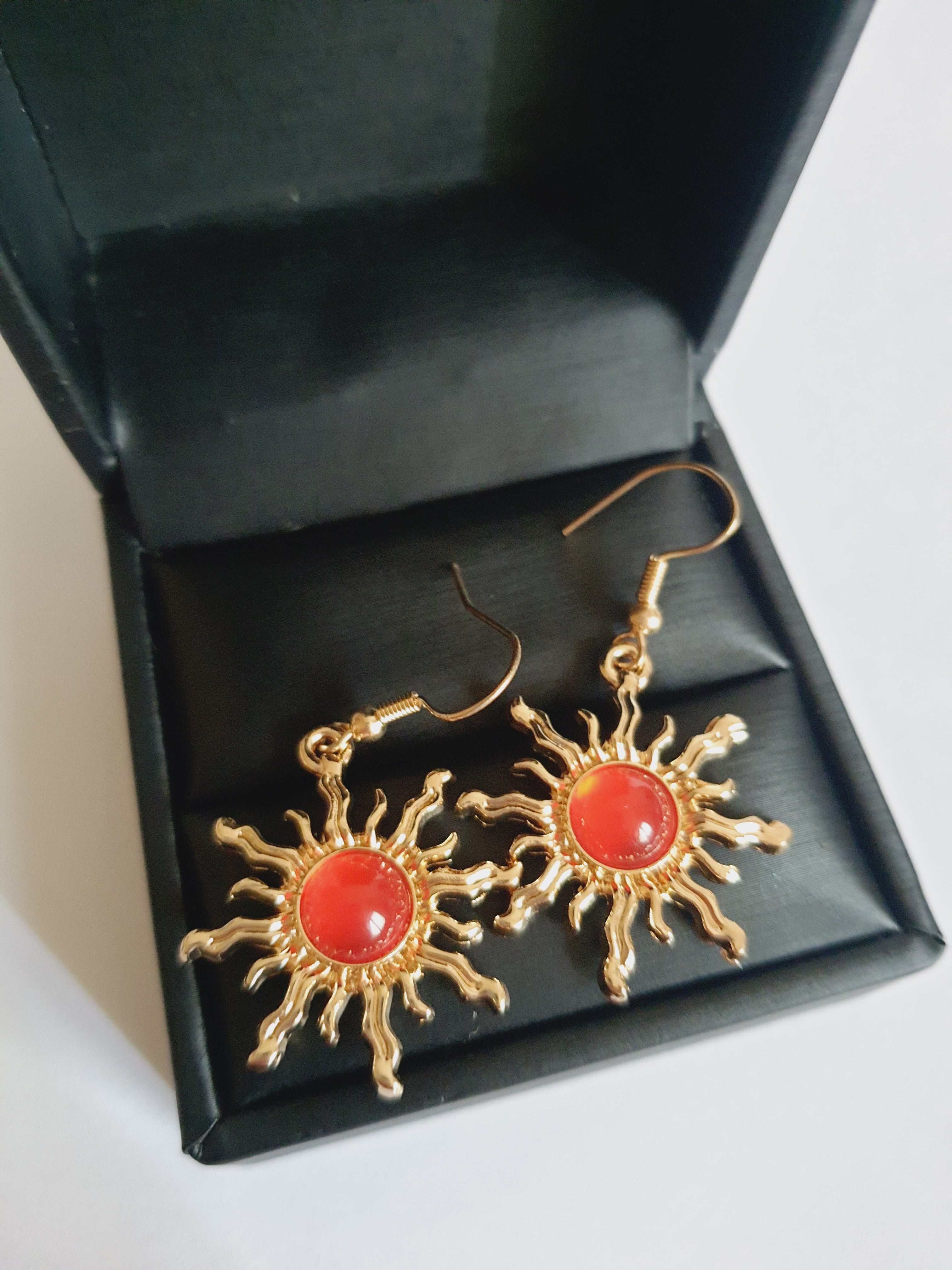 Kolczyki w kształcie słońca ze stali nierdzewnej, złocone, z centralnym czerwonym kamieniem, długość 4 cm, RougeBizu.