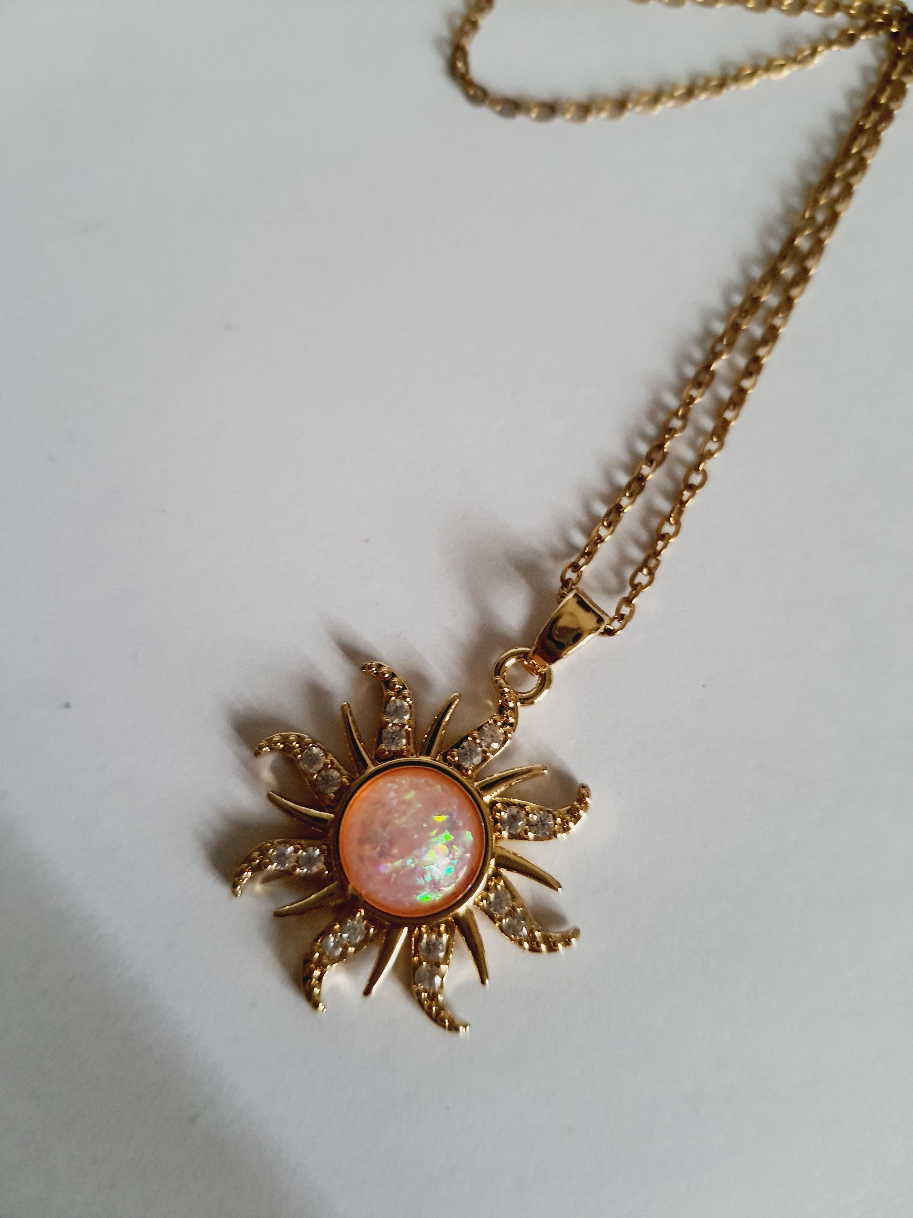 Naszyjnik złocony ze stali nierdzewnej, długość 42–47 cm, zawieszka w kształcie słońca z opalizującym kamieniem i cyrkoniami, RougeBizu.