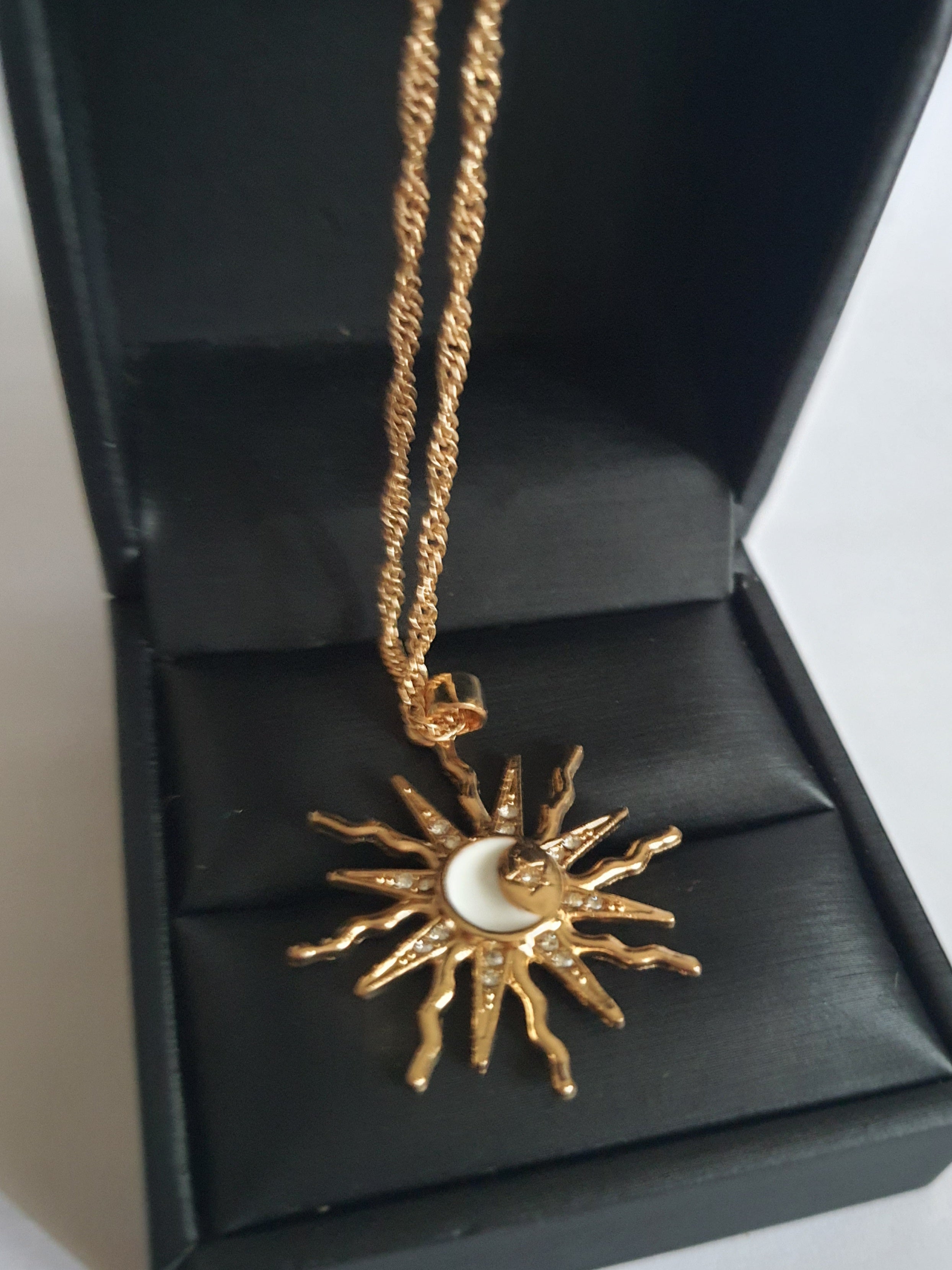 Naszyjnik ze stali nierdzewnej w kolorze złotym, z zawieszką w kształcie słońca i księżyca ozdobioną kryształkami, długość łańcuszka 42–47 cm, Rouge Bizu.