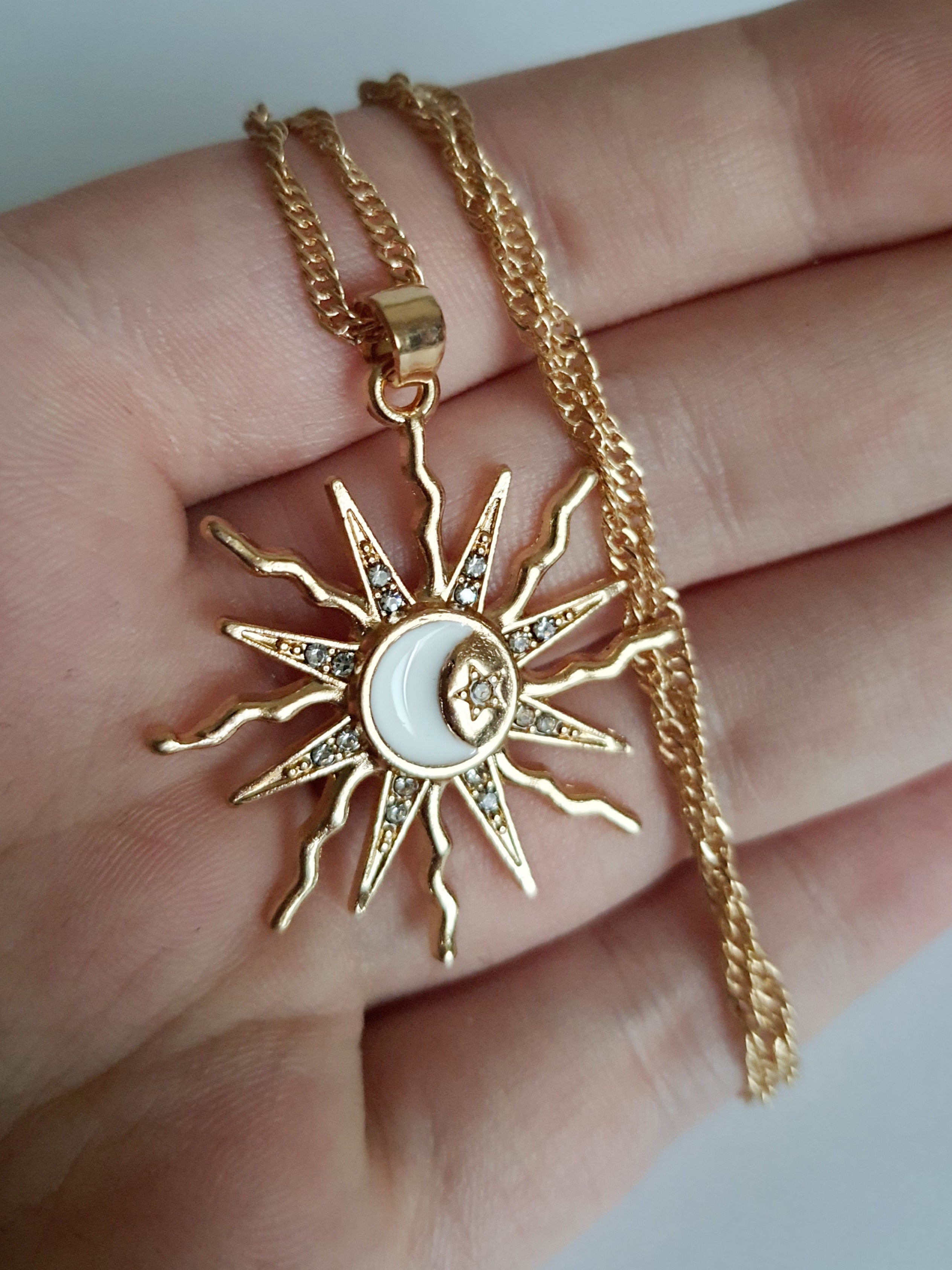 Naszyjnik ze stali nierdzewnej w kolorze złotym, z zawieszką w kształcie słońca i księżyca ozdobioną kryształkami, długość łańcuszka 42–47 cm, Rouge Bizu.