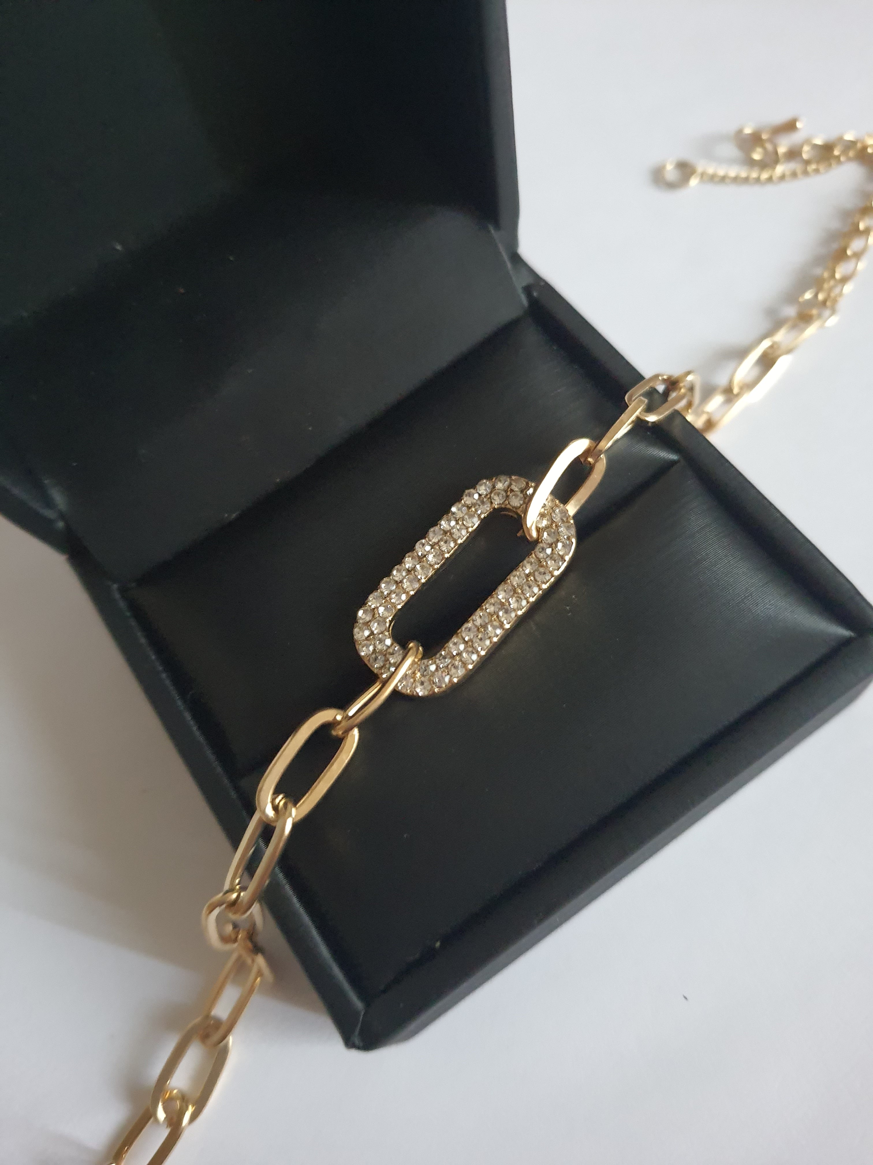 Złota bransoletka ze stali nierdzewnej z łańcuszkowym splotem i centralnym ogniwem wysadzanym transparentnymi kryształami, regulowana długość 17–22 cm, Rouge Bizu.