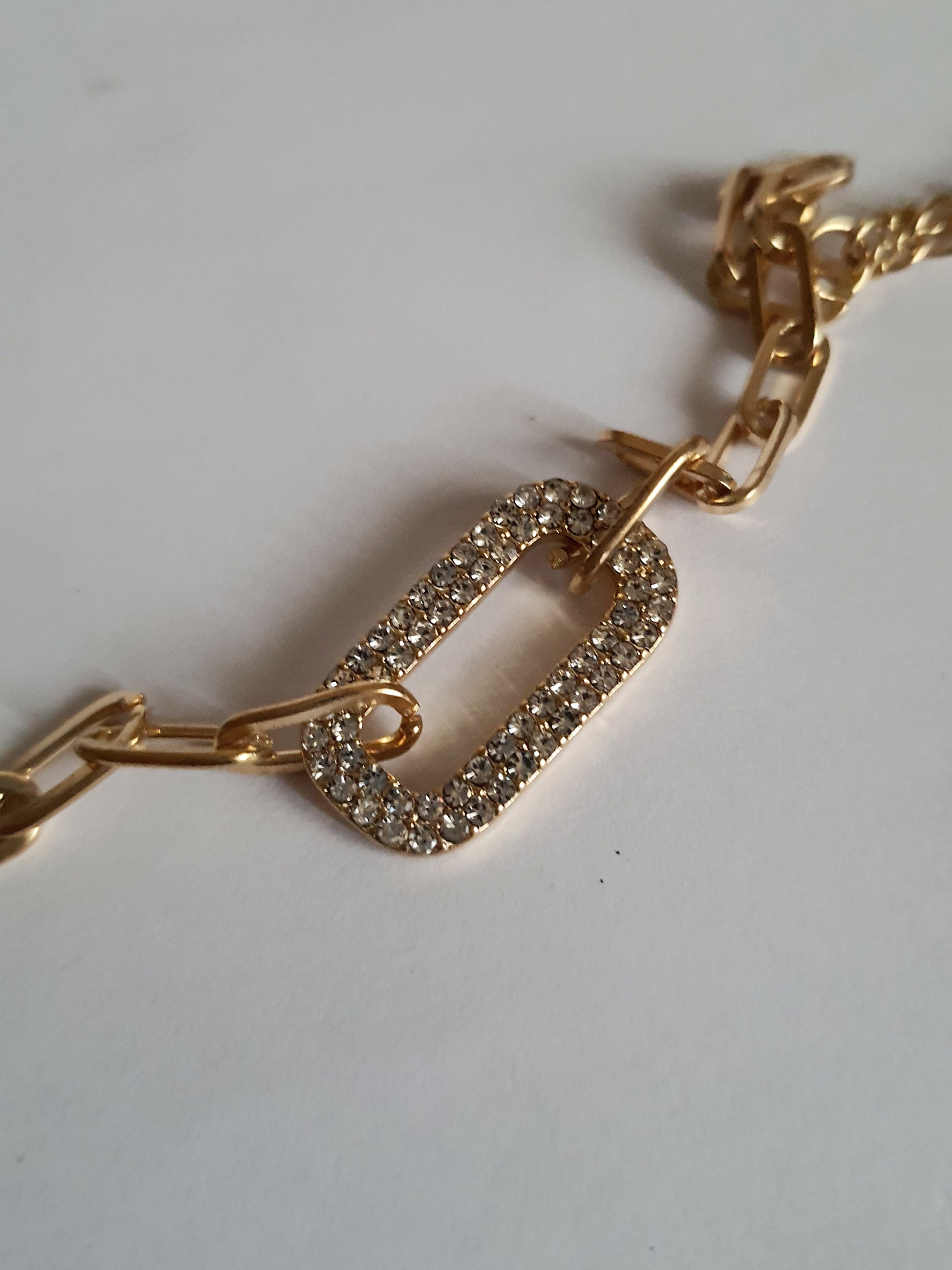 Złota bransoletka ze stali nierdzewnej z łańcuszkowym splotem i centralnym ogniwem wysadzanym transparentnymi kryształami, regulowana długość 17–22 cm, Rouge Bizu.