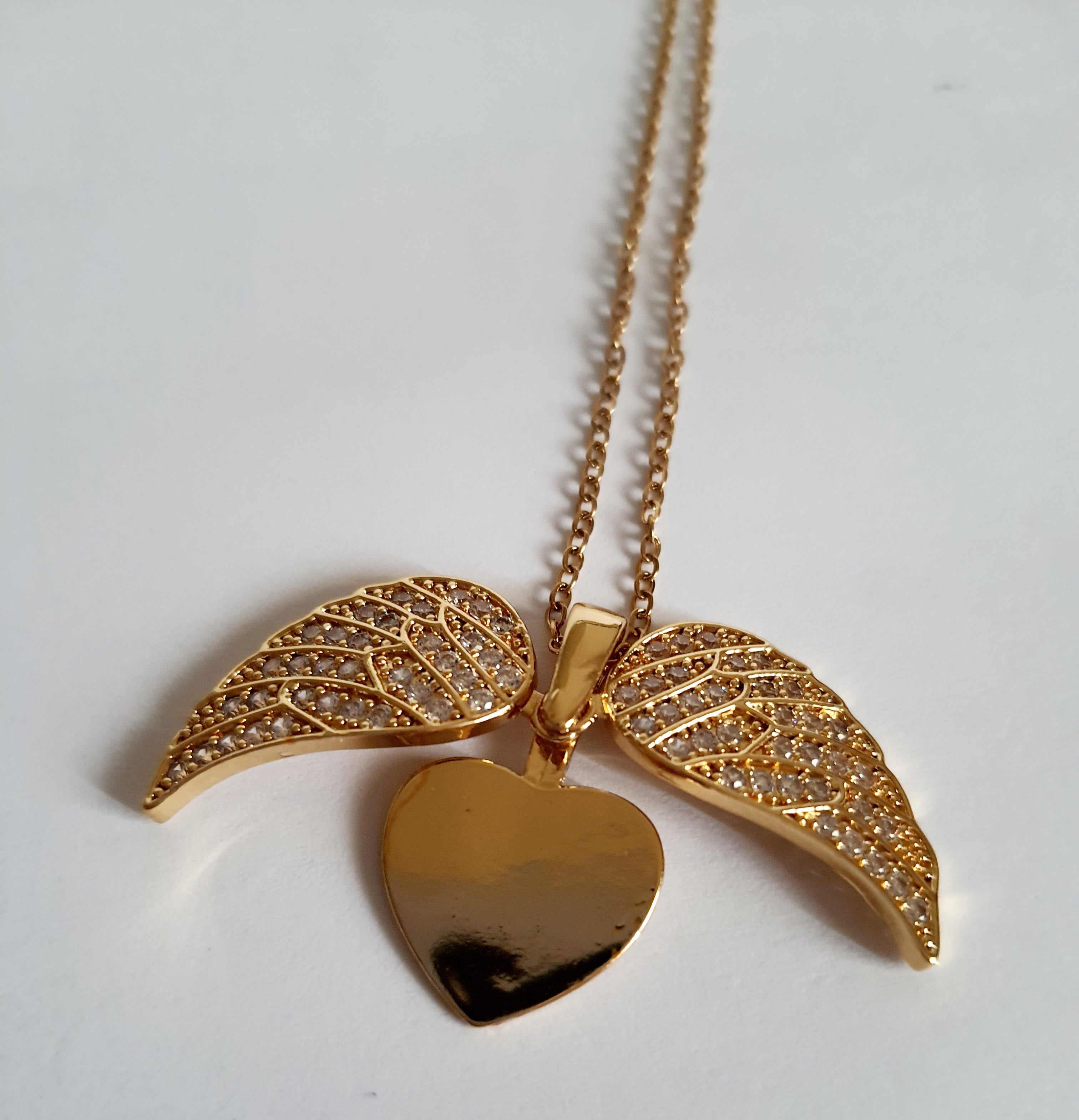 Naszyjnik ze stali nierdzewnej w kolorze złotym, z zawieszką serce i rozkładanymi skrzydłami ozdobionymi kryształkami, regulowana długość 40–45 cm, Rouge Bizu.