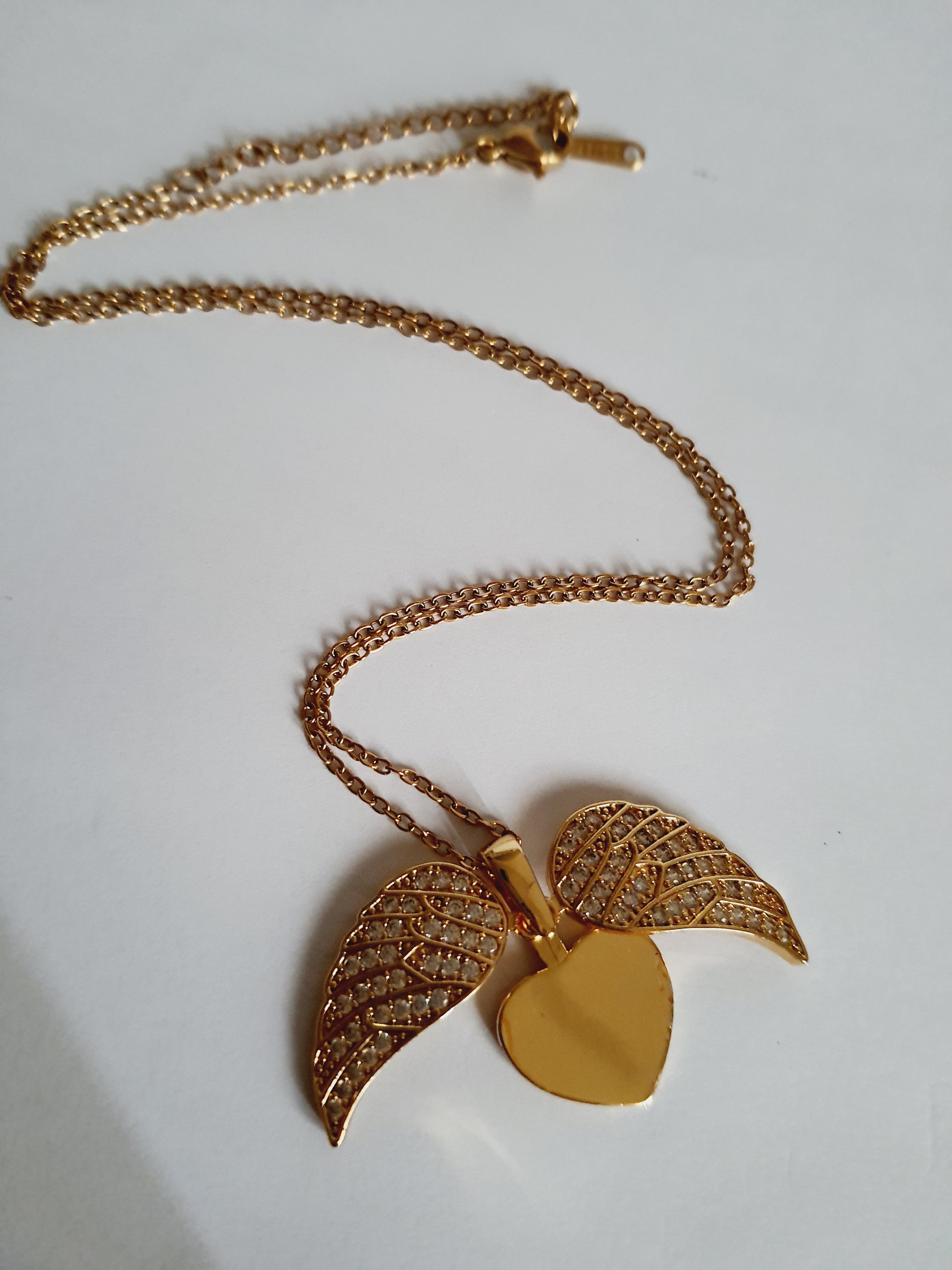 Naszyjnik ze stali nierdzewnej w kolorze złotym, z zawieszką serce i rozkładanymi skrzydłami ozdobionymi kryształkami, regulowana długość 40–45 cm, Rouge Bizu.