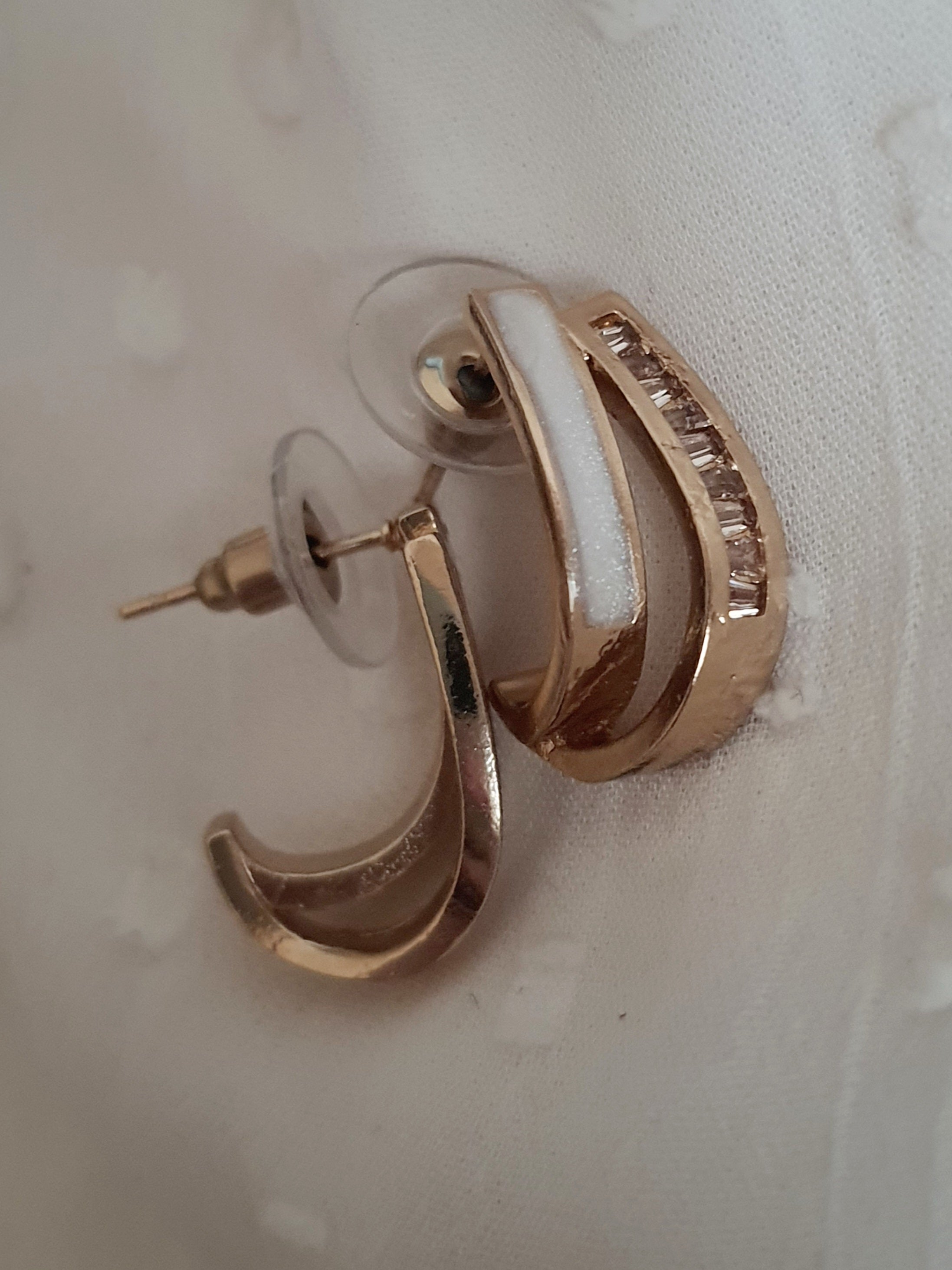 Kolczyki damskie ze stali nierdzewnej, długość 2 cm, złote półkola o nowoczesnym kształcie, ozdobione rzędem cyrkonii, minimalistyczny i elegancki styl glamour, Rouge Bizu.