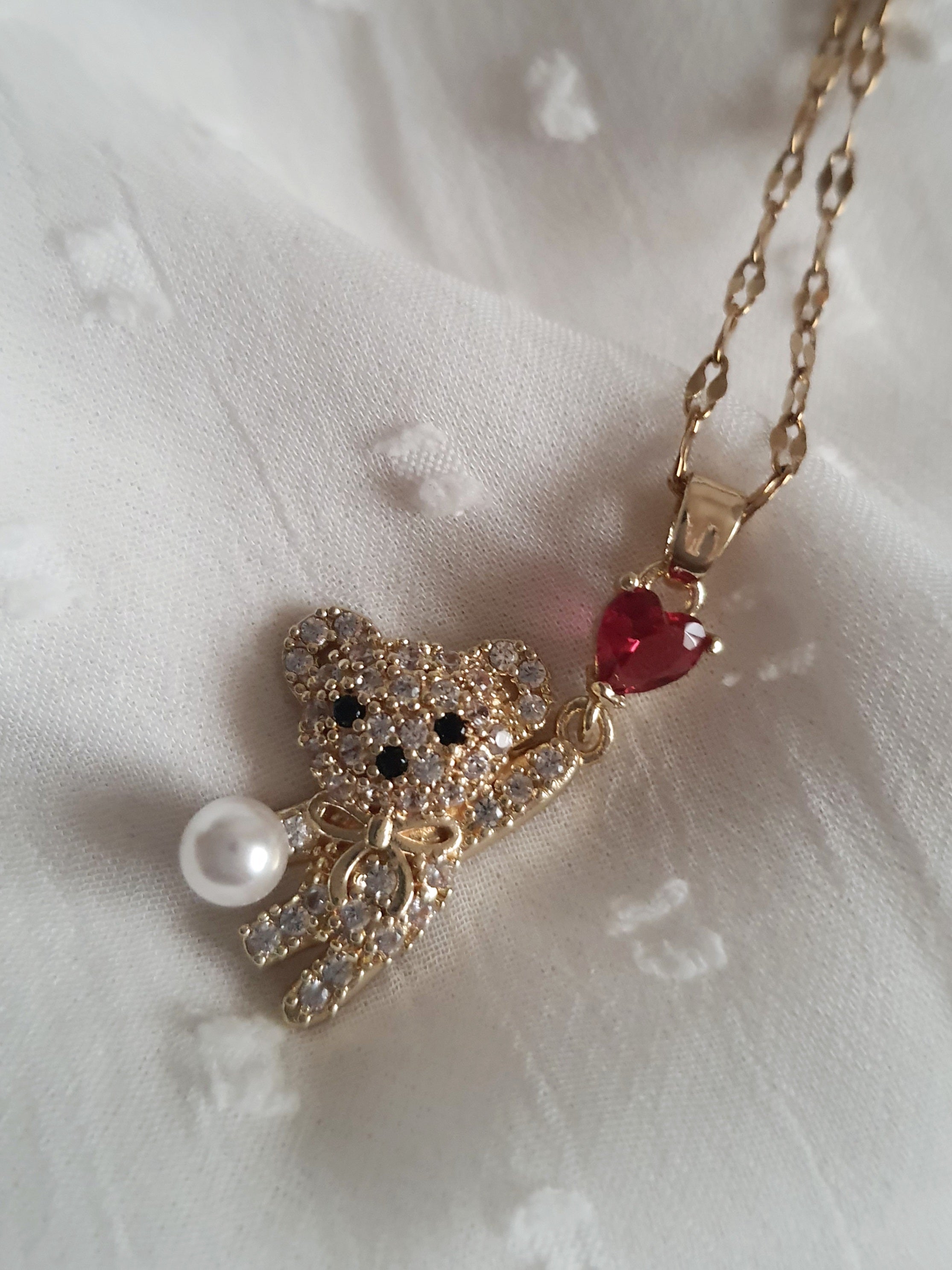 Naszyjnik damski ze stali nierdzewnej, długość regulowana 44–49 cm, złoty, zawieszka w kształcie misia wysadzanego cyrkoniami, z perłą i czerwonym sercem, styl uroczy glamour, Rouge Bizu.