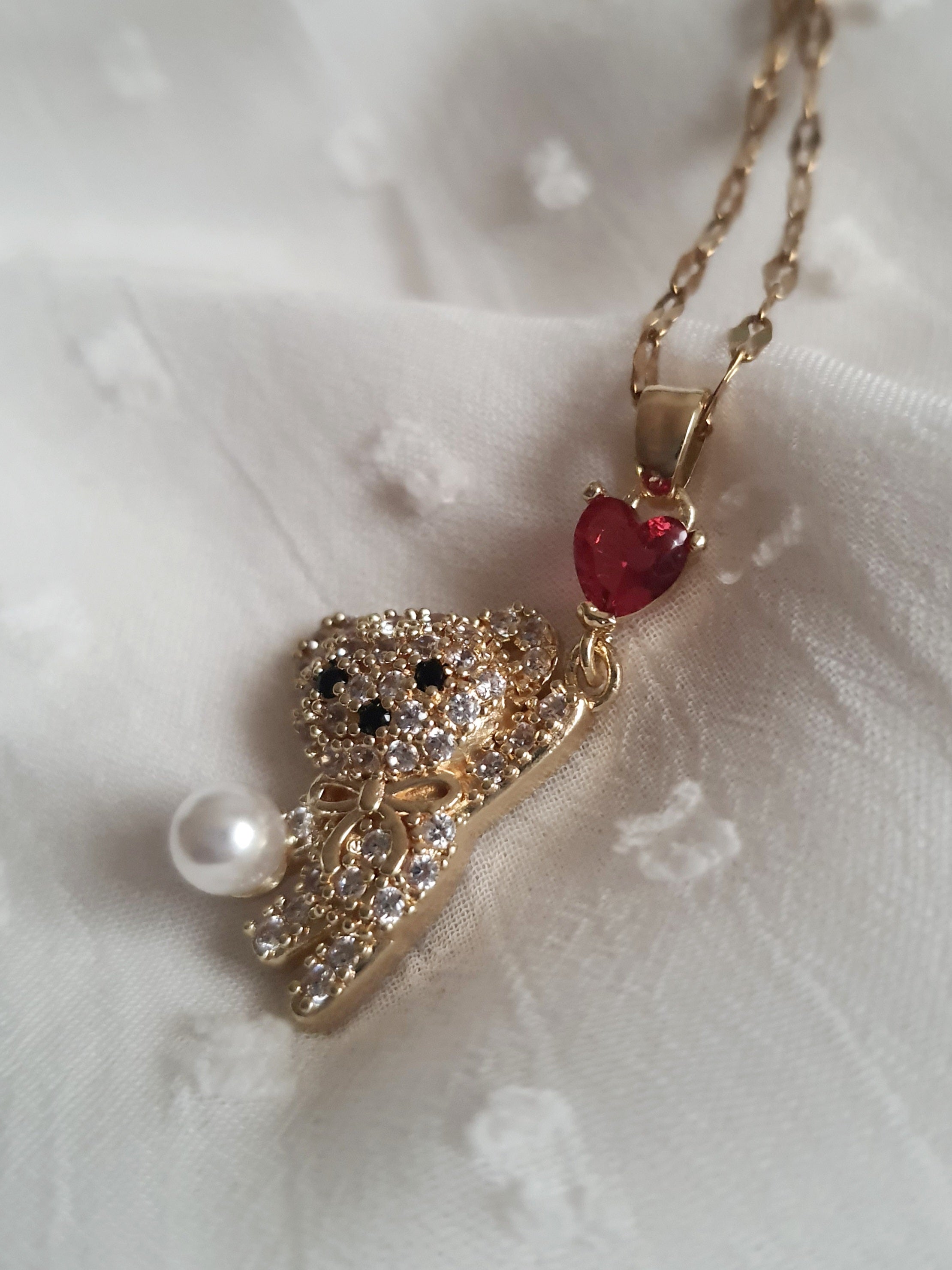 Naszyjnik damski ze stali nierdzewnej, długość regulowana 44–49 cm, złoty, zawieszka w kształcie misia wysadzanego cyrkoniami, z perłą i czerwonym sercem, styl uroczy glamour, Rouge Bizu.