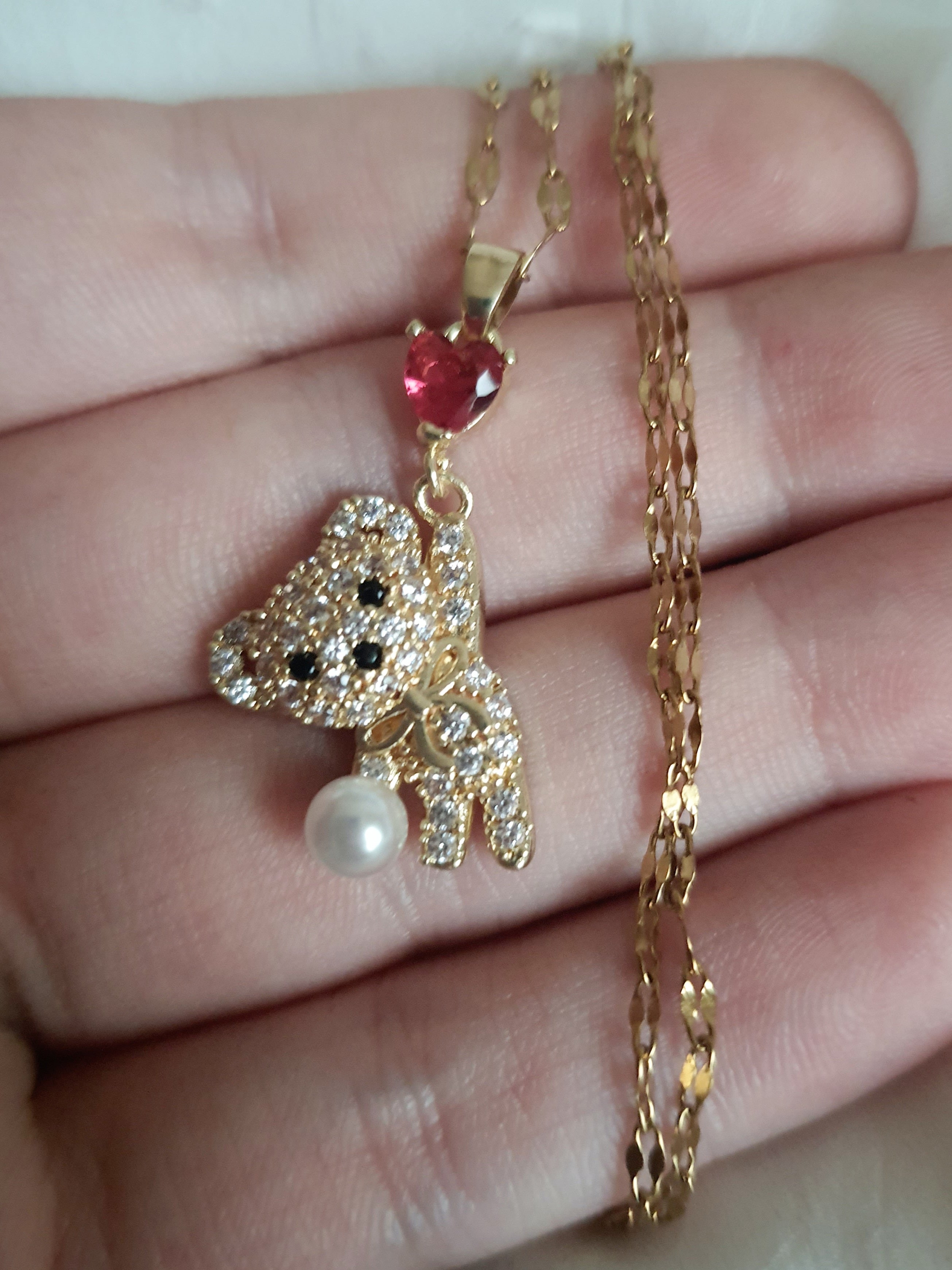 Naszyjnik damski ze stali nierdzewnej, długość regulowana 44–49 cm, złoty, zawieszka w kształcie misia wysadzanego cyrkoniami, z perłą i czerwonym sercem, styl uroczy glamour, Rouge Bizu.
