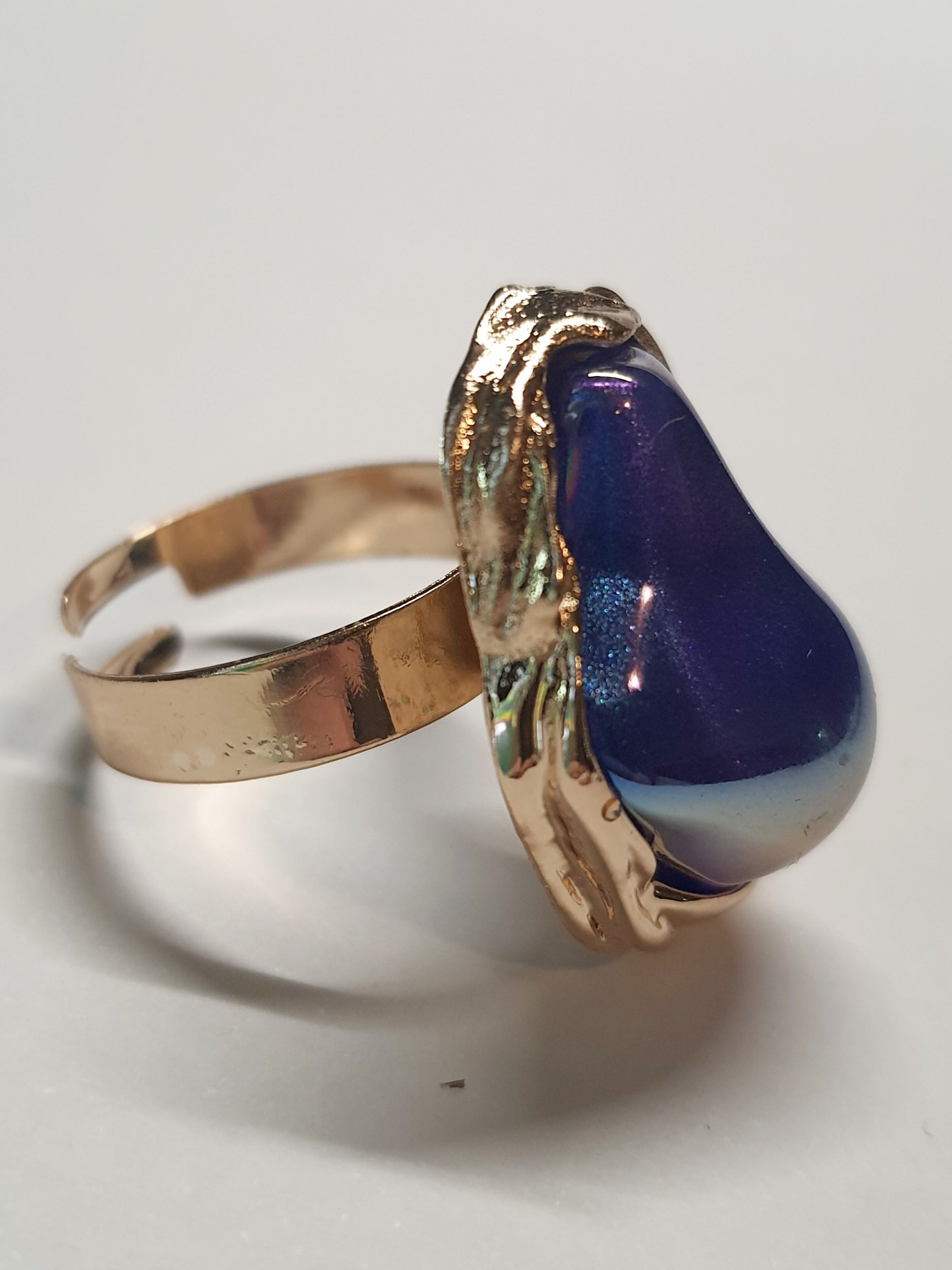 Pierścionek Aurora ze stali chirurgicznej, stal nierdzewna, złota oprawa z opalizującym kamieniem w kolorach fioletu i błękitu, styl glamour, rozmiar 18 mm, wodoodporny, hipoalergiczny, jakość premium, Rouge Bizu.
