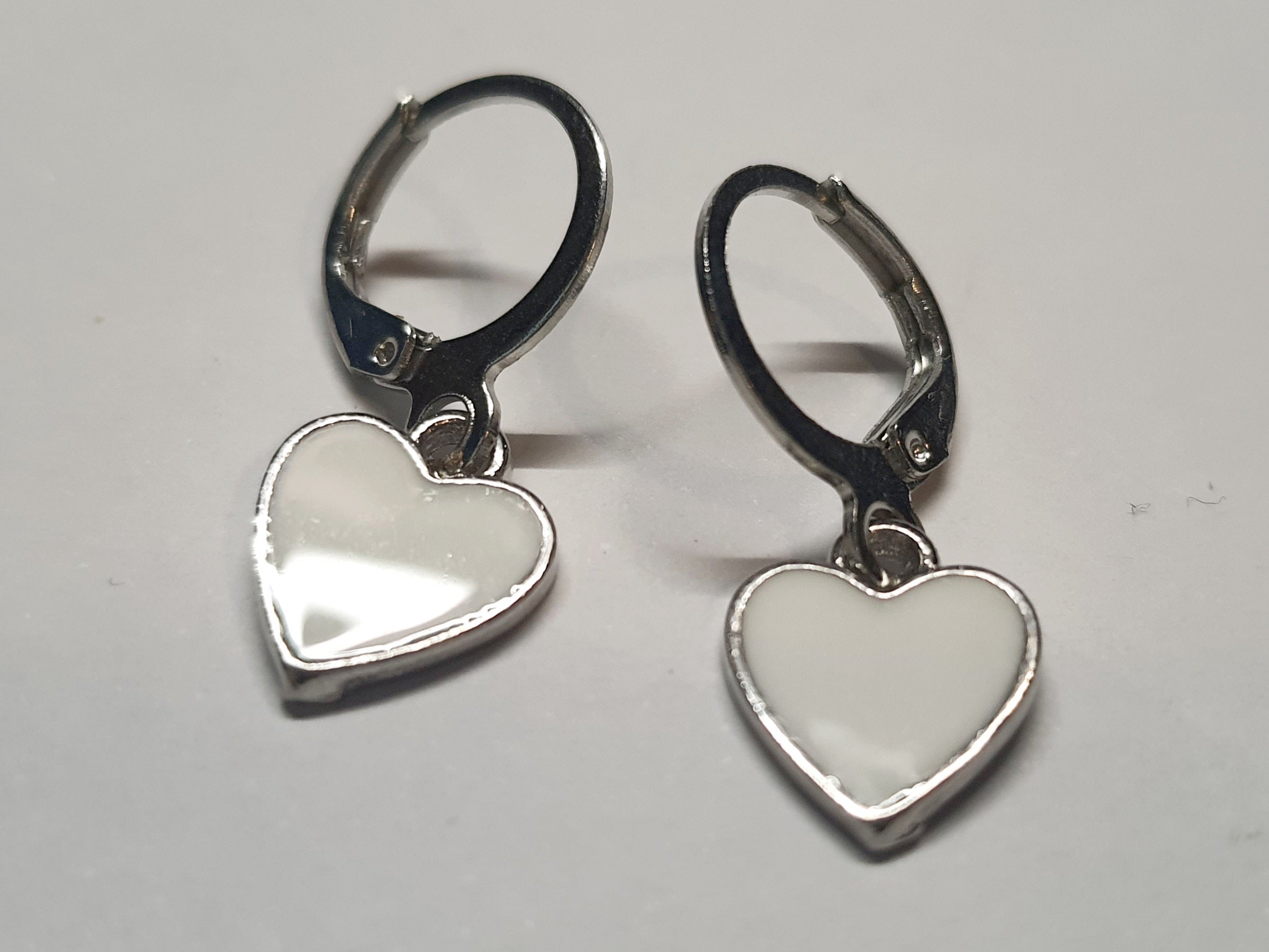 Srebrne kolczyki delikatne kółka z zawieszką w kształcie serca z białą emalią, długość 2,5 cm, stal chirurgiczna, stal nierdzewna, wodoodporne, hipoalergiczne, jakość premium, RougeBizu.