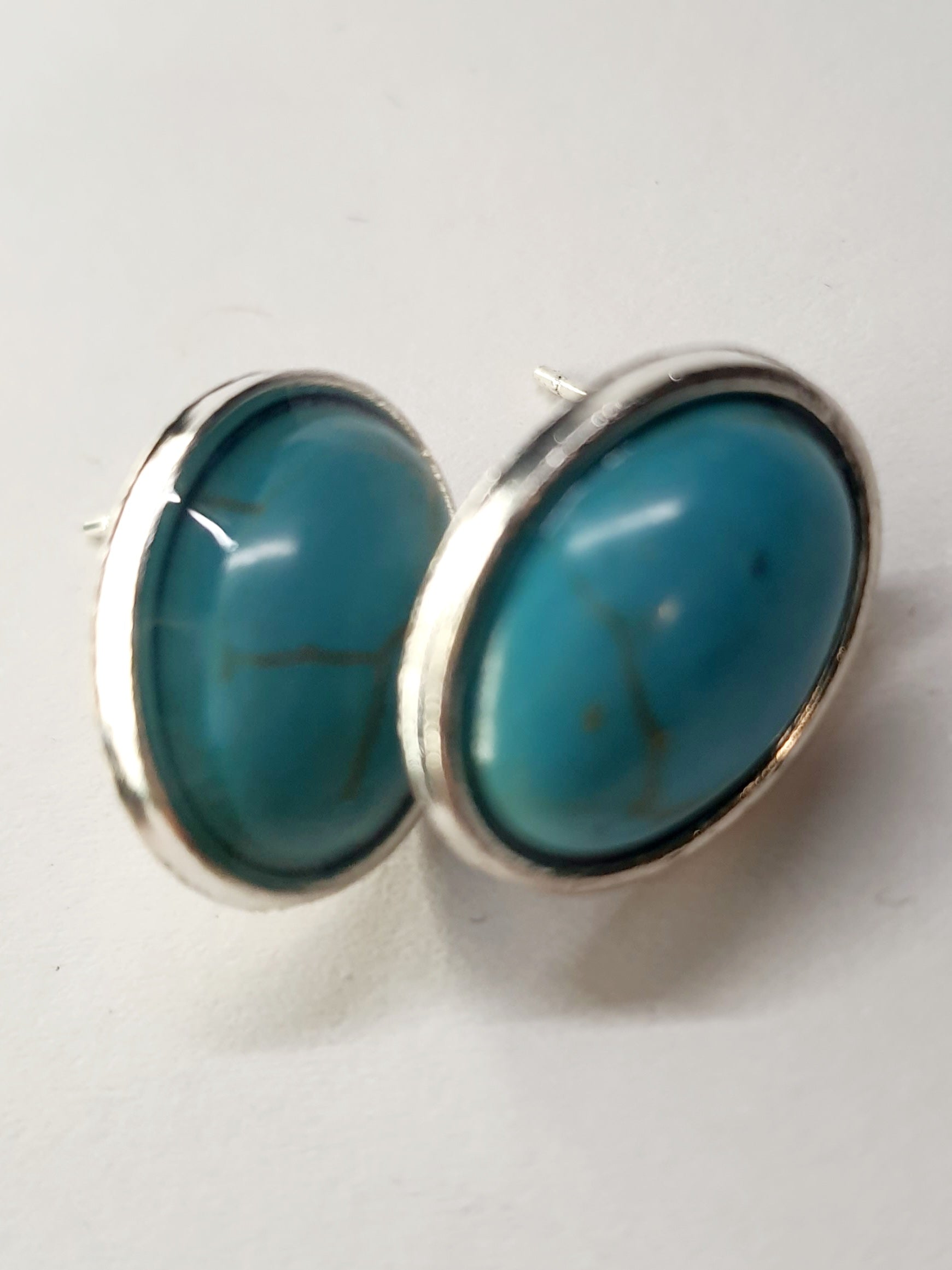 Kolczyki owalne z turkusowym kamieniem w srebrnej oprawie. Średnica 1,8 cm. Styl minimalistyczny, elegancki. Stal nierdzewna, stal chirurgiczna, wodoodporne, hipoalergiczne, jakość premium. Rouge Bizu.