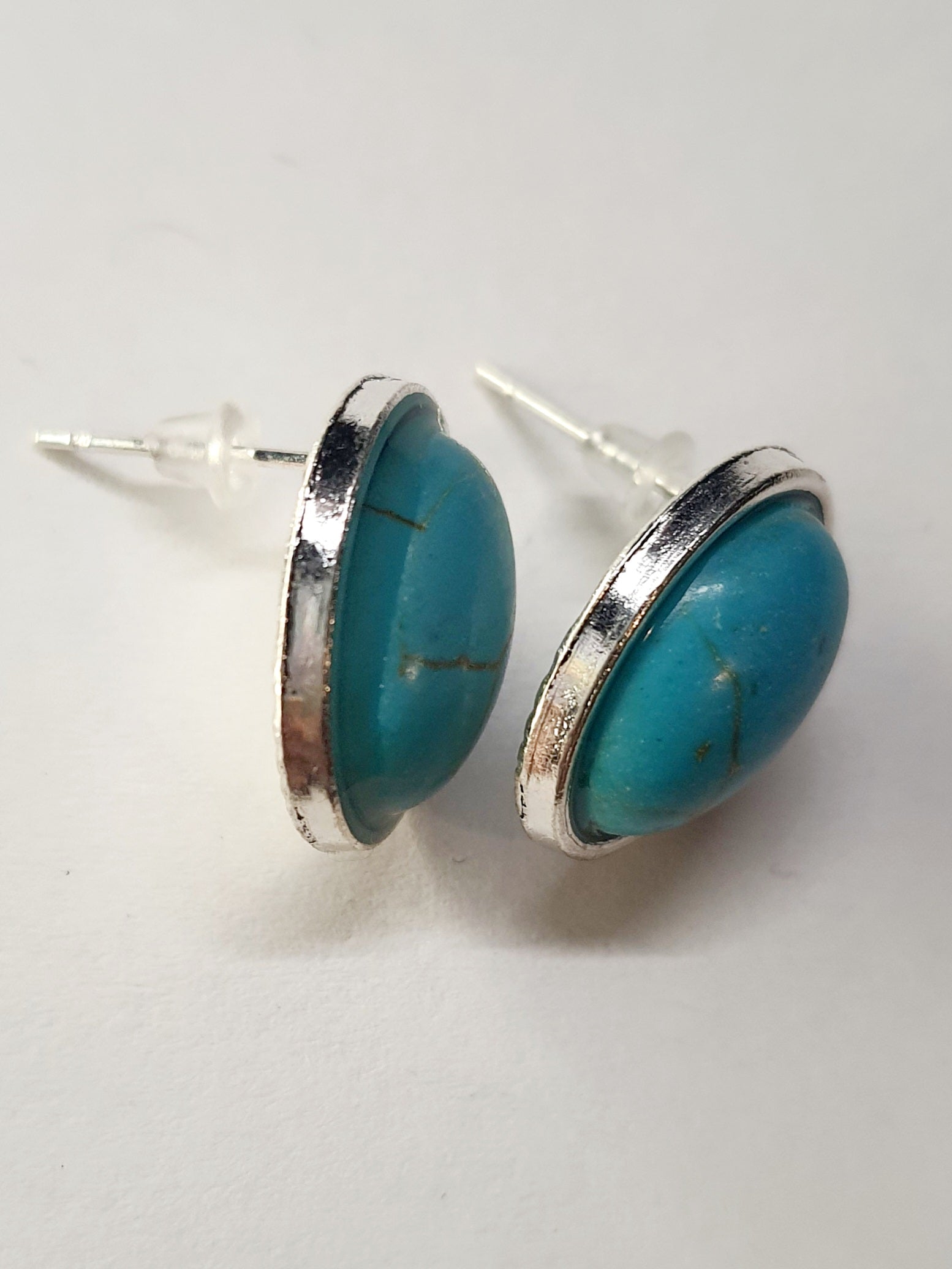 Kolczyki owalne z turkusowym kamieniem w srebrnej oprawie. Średnica 1,8 cm. Styl minimalistyczny, elegancki. Stal nierdzewna, stal chirurgiczna, wodoodporne, hipoalergiczne, jakość premium. Rouge Bizu.