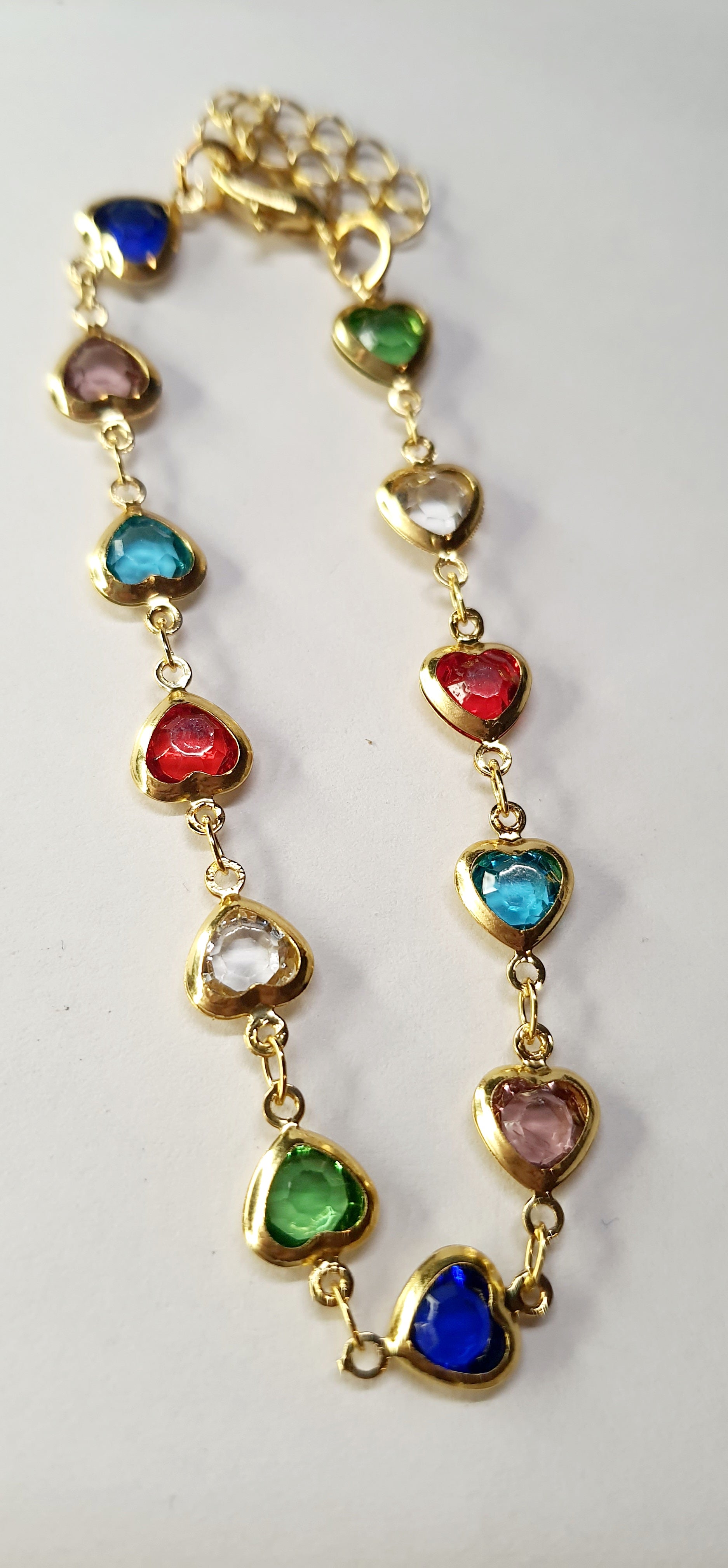 Złota bransoletka z kolorowymi serduszkami, długość regulowana 17–22 cm, styl romantyczny i glamour. Stal nierdzewna, stal chirurgiczna, wodoodporne, hipoalergiczne, jakość premium, Rouge Bizu.