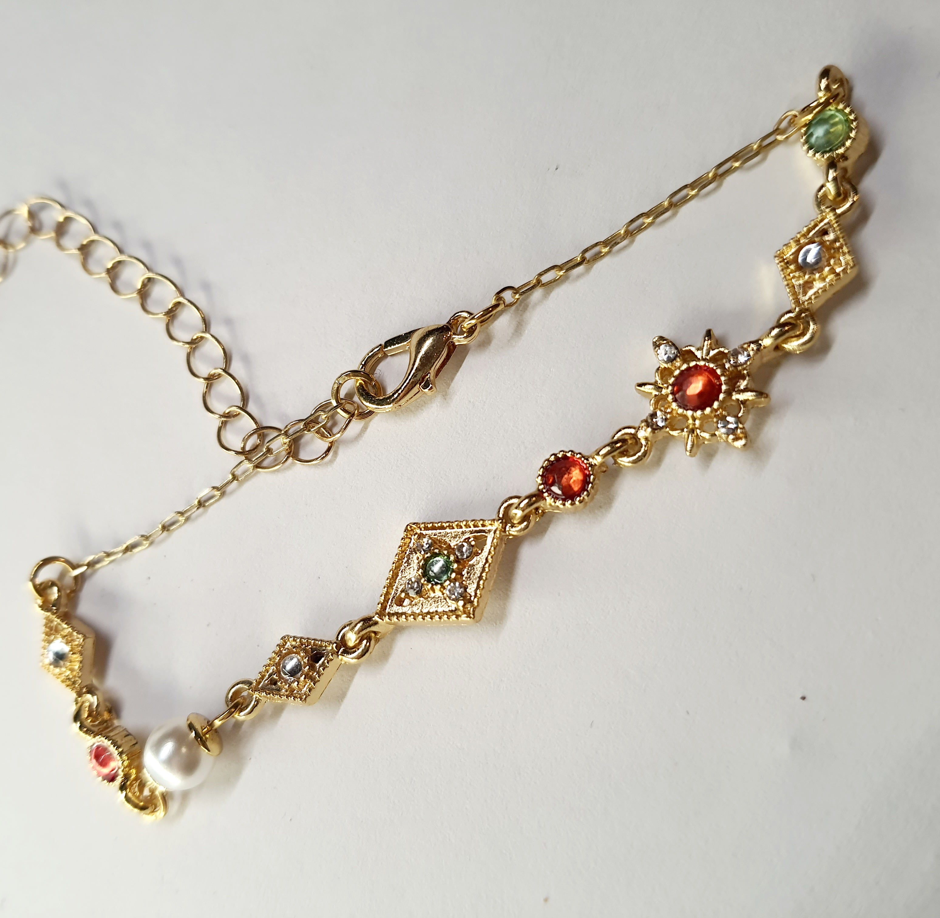 Złota bransoletka z kolorowymi kamieniami – czerwonymi, zielonymi i białymi, długość regulowana 18–25 cm, styl vintage orientalny. Stal nierdzewna, stal chirurgiczna, wodoodporne, hipoalergiczne, jakość premium, Rouge Bizu.