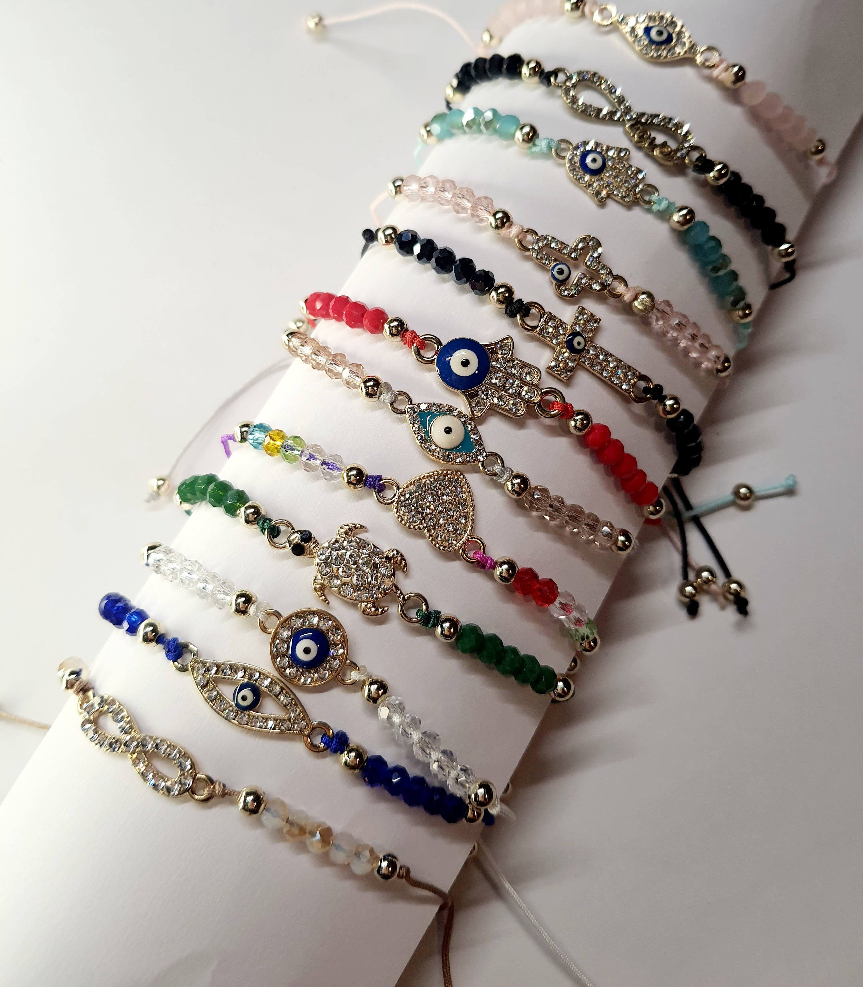 Bransoletka na czerwonym sznurku z zawieszką w kształcie dłoni Fatimy z okiem proroka, zdobioną cyrkoniami. Styl boho i amulet ochronny. Stal chirurgiczna, stal nierdzewna, wodoodporne, hipoalergiczne, jakość premium. Rouge Bizu.