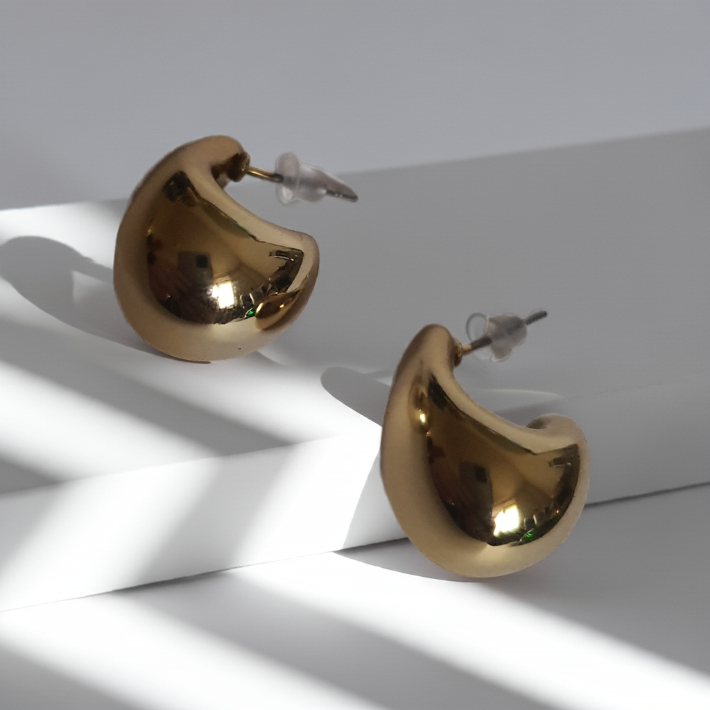 „Złote kolczyki krople o długości 2 cm, wykonane ze stali nierdzewnej, o lśniącej powierzchni w nowoczesnym, organicznym stylu – Rouge Bizu.”