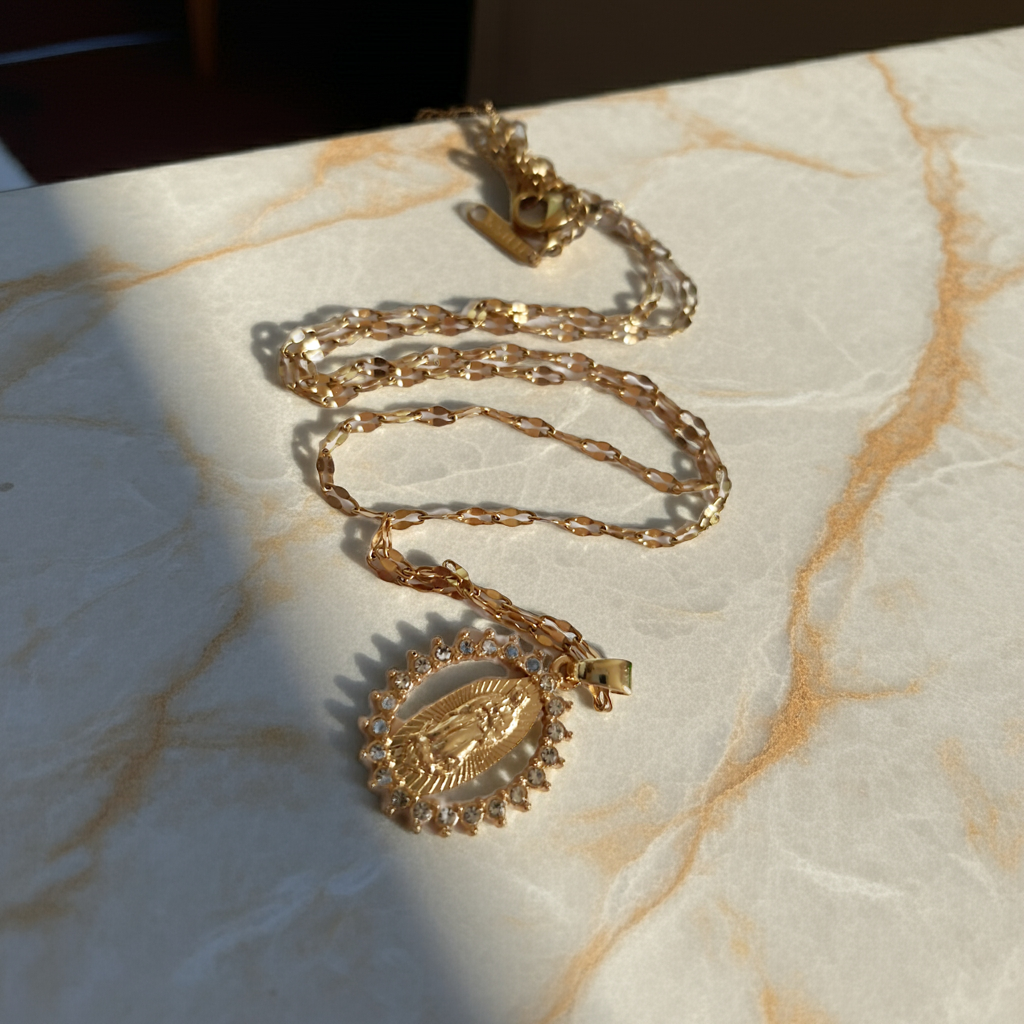 Złoty łańcuszek o długości 40–46 cm z wisiorkiem Matki Boskiej otoczonym cyrkoniami. Styl sakralny, elegancki. Stal nierdzewna, Rouge Bizu.