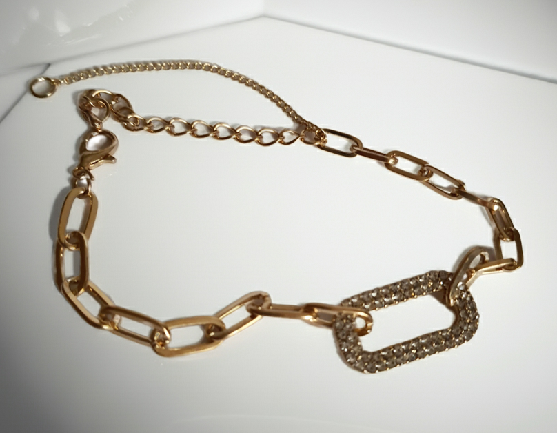 Złota bransoletka ze stali nierdzewnej z łańcuszkowym splotem i centralnym ogniwem wysadzanym transparentnymi kryształami, regulowana długość 17–22 cm, Rouge Bizu.