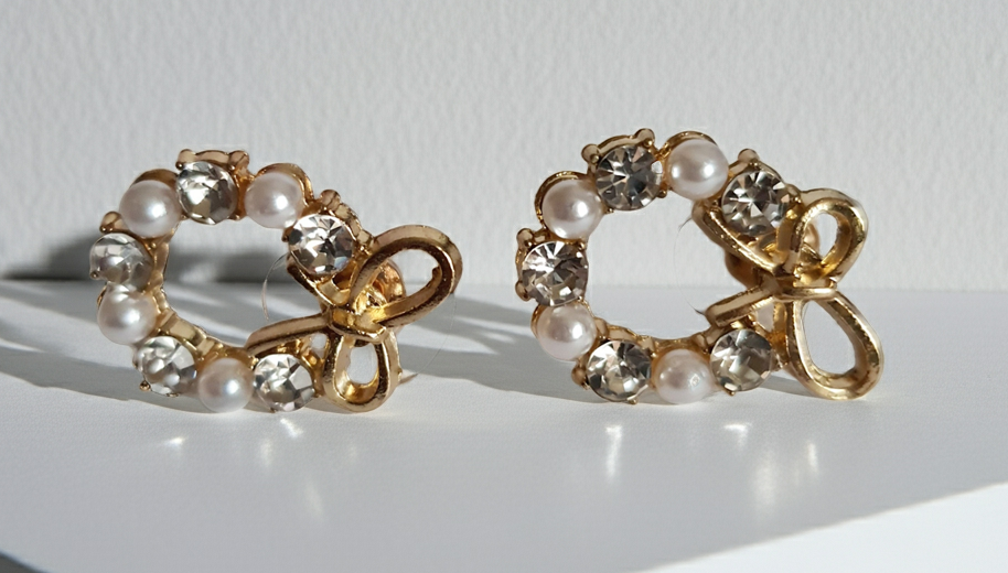 Złote kolczyki kokardki z perełkami i kryształami – romantyczna elegancja