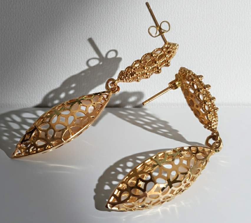 Złote kolczyki ze stali nierdzewnej w kształcie ażurowych liści. Eleganckie, lekkie i subtelne, idealne na co dzień i na wieczór. Długość 5,5 cm. Rouge Bizu.