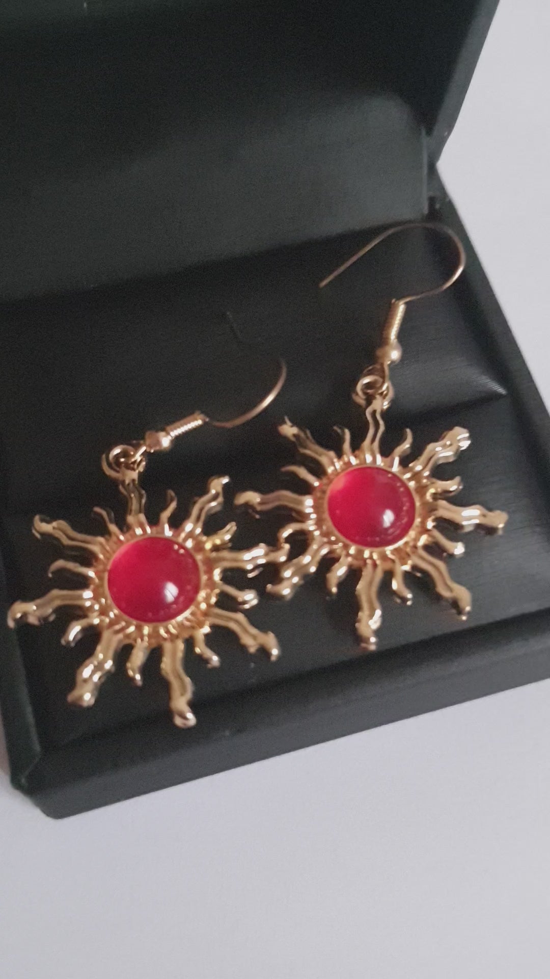 Kolczyki w kształcie słońca ze stali nierdzewnej, złocone, z centralnym czerwonym kamieniem, długość 4 cm, RougeBizu.