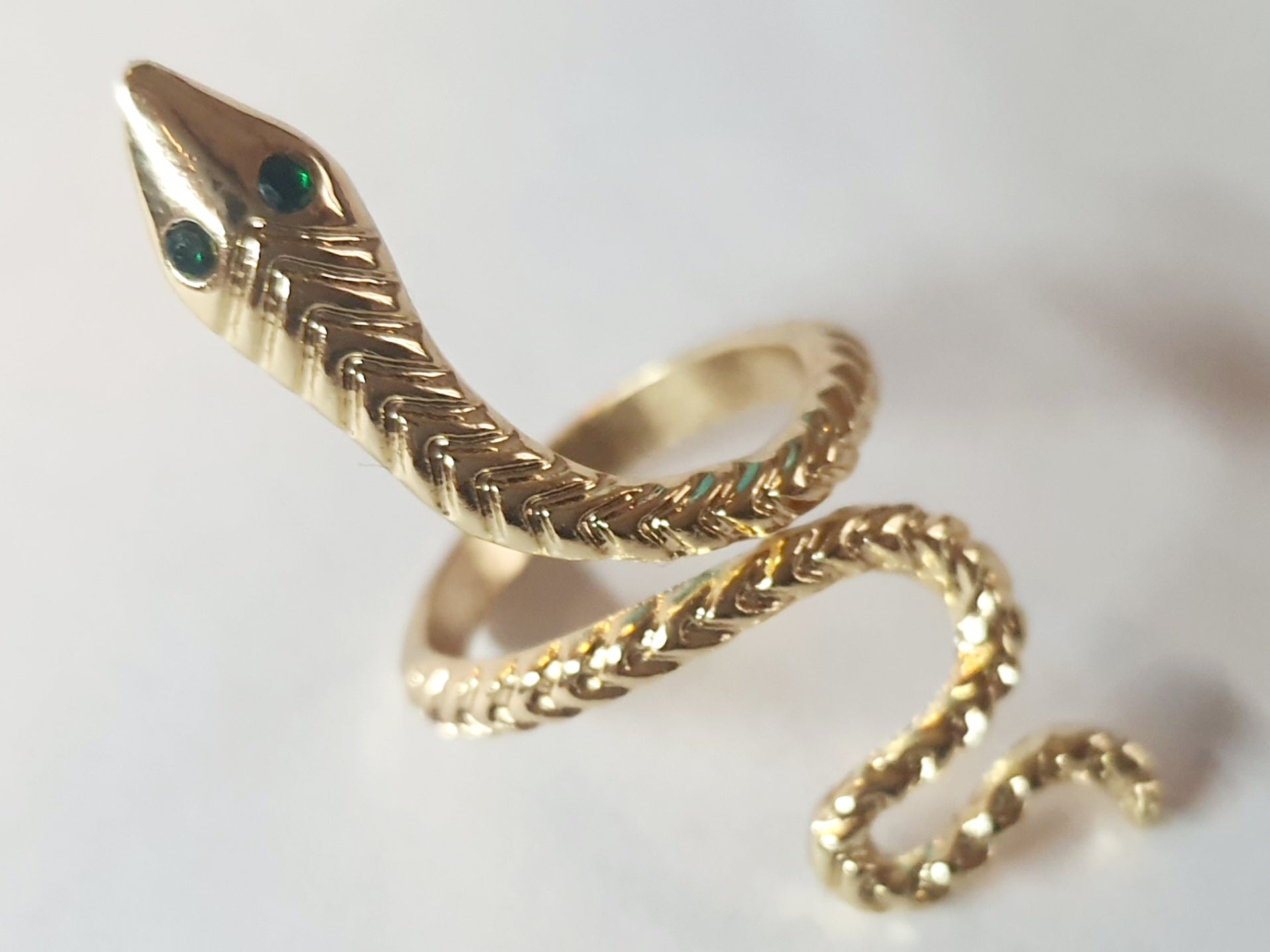 „Złoty pierścionek w kształcie węża z zielonymi oczkami, rozmiar 15 mm, wykonany ze stali nierdzewnej. Statement jewelry, modny i odważny design – Rouge Bizu.”