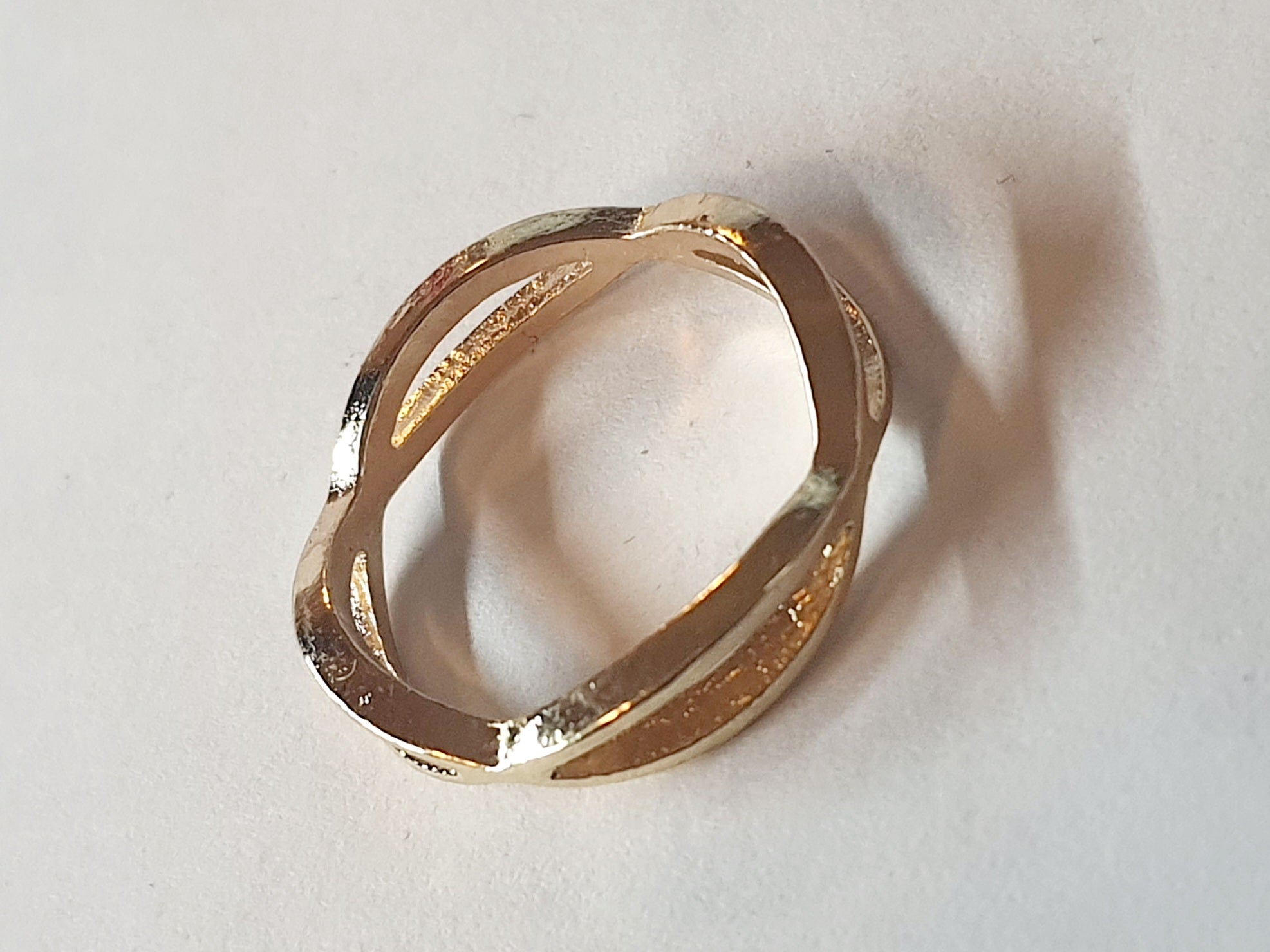 „Złoty pierścionek ze stali nierdzewnej, rozmiar 19 mm, przeplatana forma. Minimalistyczny, rzeźbiarski i modny design – Rouge Bizu.”