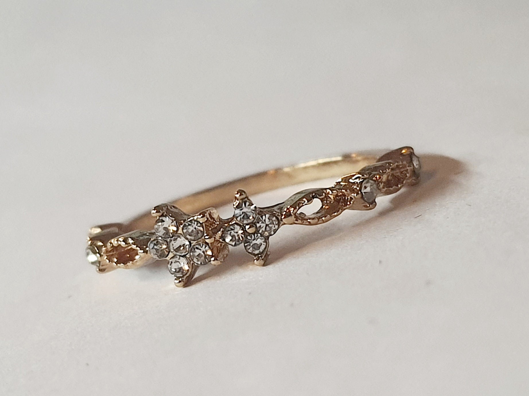 Złoty pierścionek ze stali chirurgicznej z cyrkoniami w kształcie kwiatów, rozmiar 17 mm, delikatny i elegancki styl. Stal nierdzewna, wodoodporne, hipoalergiczne, jakość premium. Rouge Bizu.