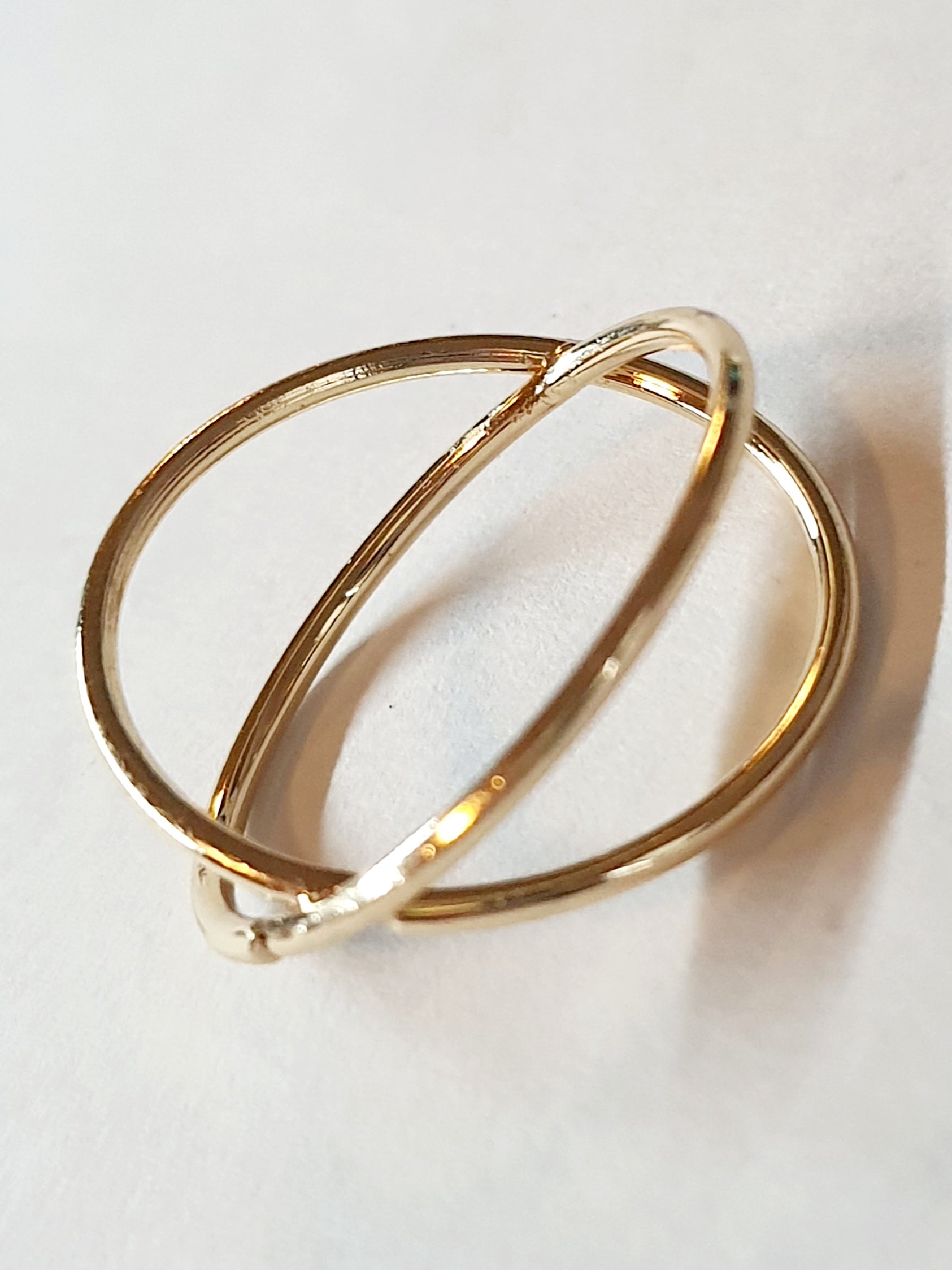 Złoty pierścionek krzyżowany ze stali chirurgicznej, otwarty, nowoczesny design, rozmiar 20 mm, połyskliwy minimalistyczny styl. Stal nierdzewna, wodoodporne, hipoalergiczne, jakość premium. Rouge Bizu.