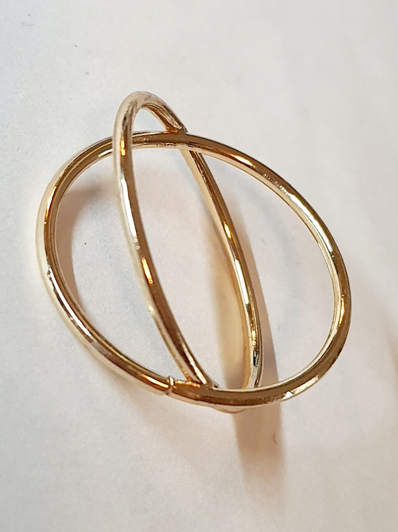 Złoty pierścionek krzyżowany ze stali chirurgicznej, otwarty, nowoczesny design, rozmiar 20 mm, połyskliwy minimalistyczny styl. Stal nierdzewna, wodoodporne, hipoalergiczne, jakość premium. Rouge Bizu.