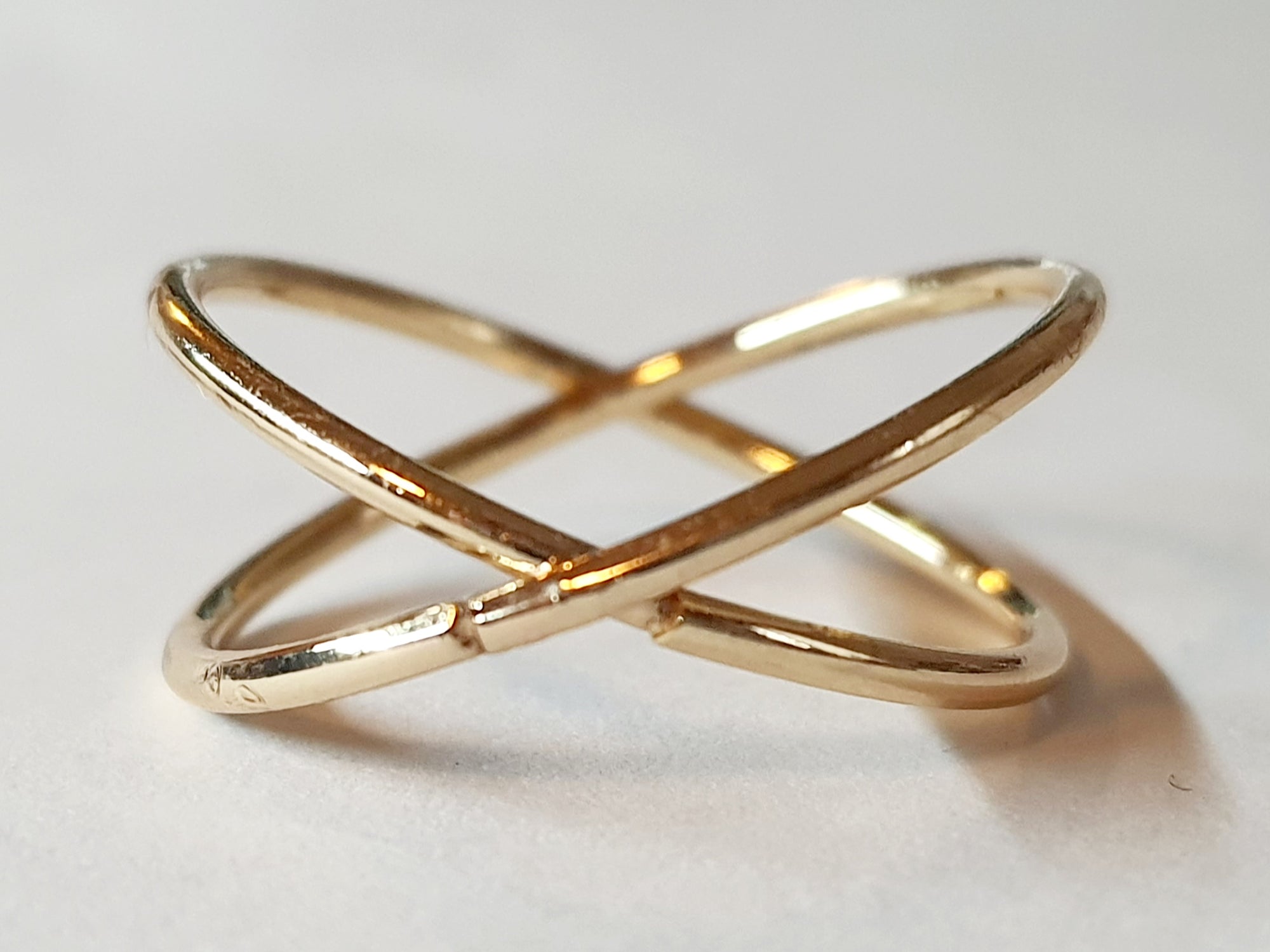 Złoty pierścionek krzyżowany ze stali chirurgicznej, otwarty, nowoczesny design, rozmiar 20 mm, połyskliwy minimalistyczny styl. Stal nierdzewna, wodoodporne, hipoalergiczne, jakość premium. Rouge Bizu.