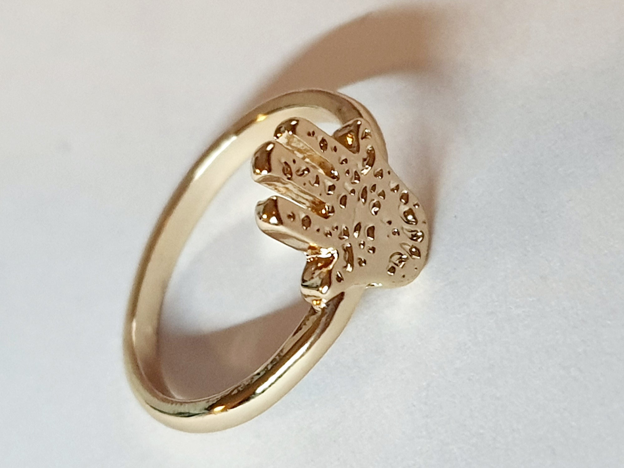 Złoty pierścionek ze stali nierdzewnej z motywem dłoni Hamsa (Ręki Fatimy). Orientalny i symboliczny design. Rozmiar 16 mm. Rouge Bizu.